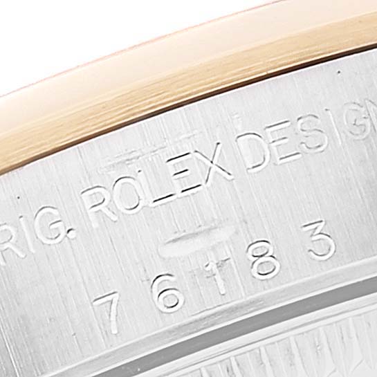 This image shows a close-up of the watch bezel and casing of a Rolex Oyster Perpetual 76183 Women's Steel and Gold (two tone) Grey Dial 76183 Women's Steel and Gold (two tone) Grey Dial, revealing part of its design and serial number.