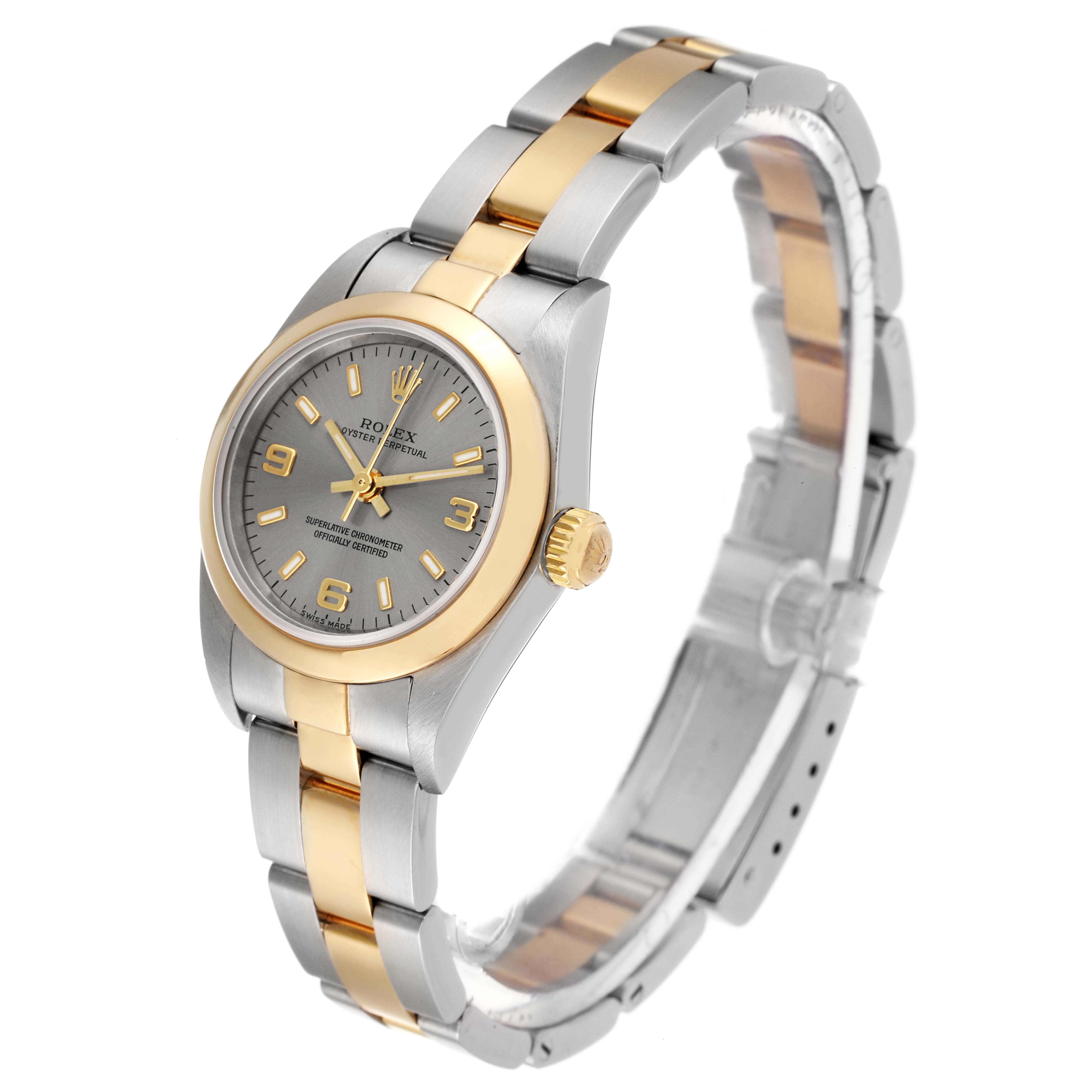 The image shows a Rolex Oyster Perpetual 76183 Women's Steel and Gold (two tone) Grey Dial 76183 Women's Steel and Gold (two tone) Grey Dial watch at an oblique angle, highlighting its gray dial, gold bezel, and two-tone bracelet.