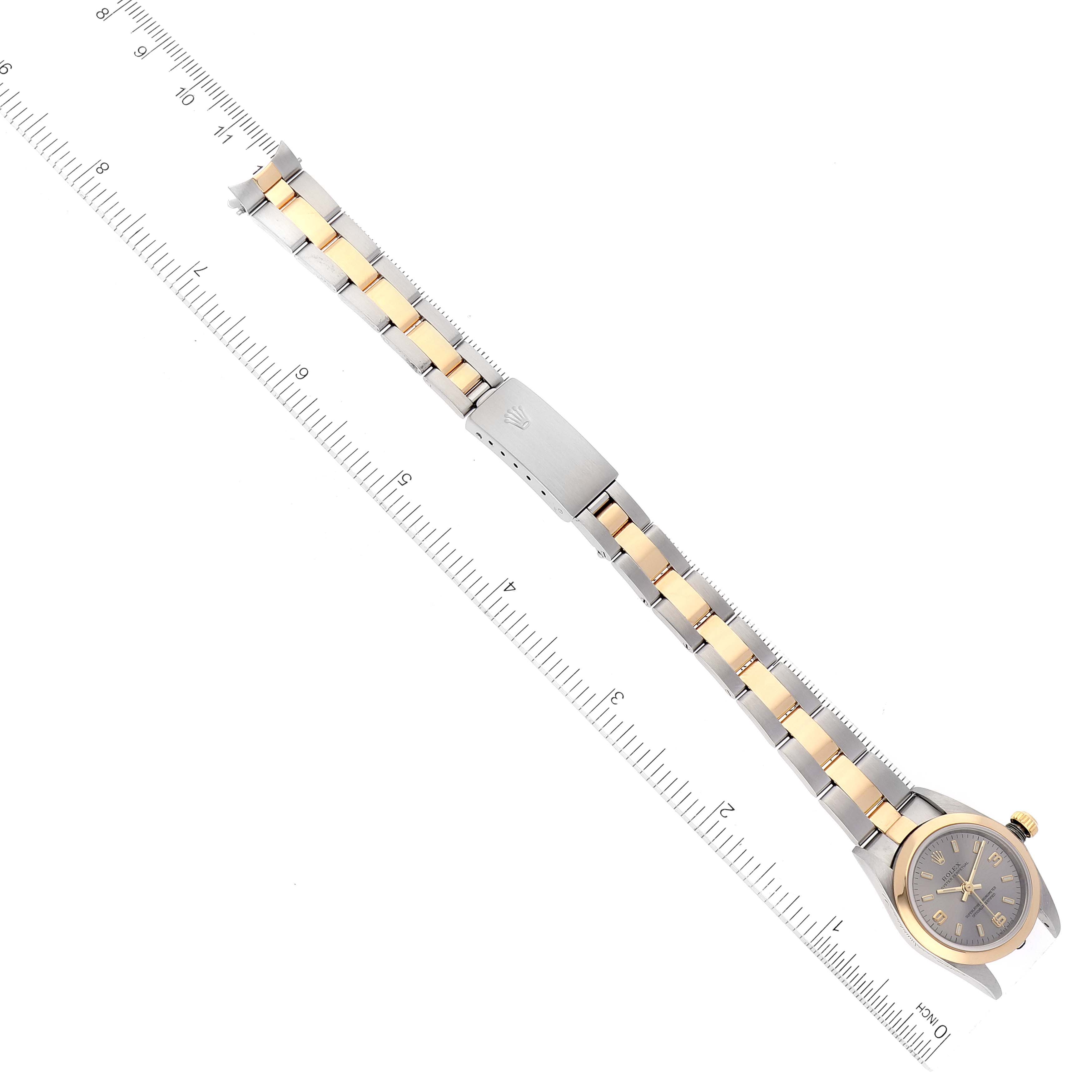 The image shows a Rolex Oyster Perpetual 76183 Women's Steel and Gold (two tone) Grey Dial 76183 Women's Steel and Gold (two tone) Grey Dial watch laid flat with its bracelet and clasp fully extended next to a ruler.