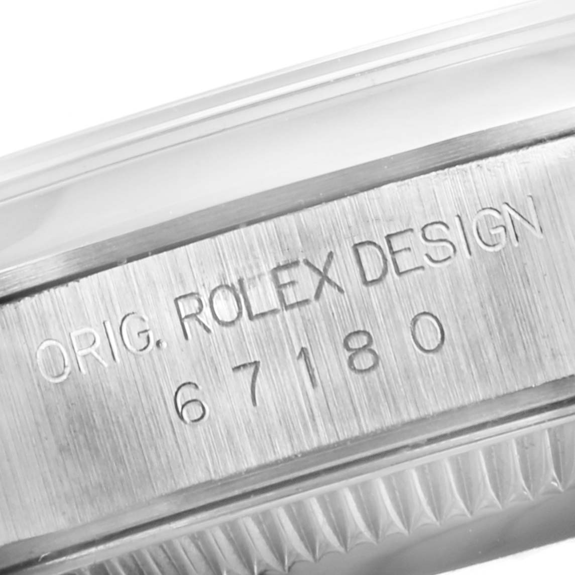 This close-up image shows the side engraving of a Rolex Oyster Perpetual 67180 Women's Stainless Steel White Dial 67180 Women's Stainless Steel White Dial watch, featuring its model number and "ORIG. ROLEX DESIGN."