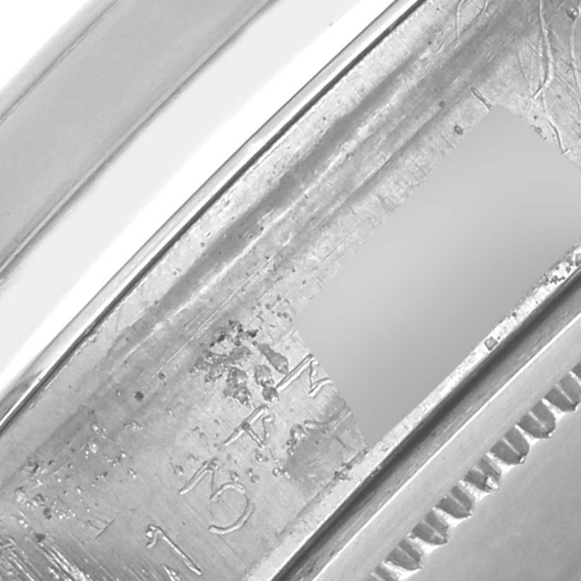 The image shows a close-up of the Rolex Date 6694 Men's Stainless Steel Black Dial 6694 Men's Stainless Steel Black Dial model's case, particularly focusing on the inner rim with some engraved details.