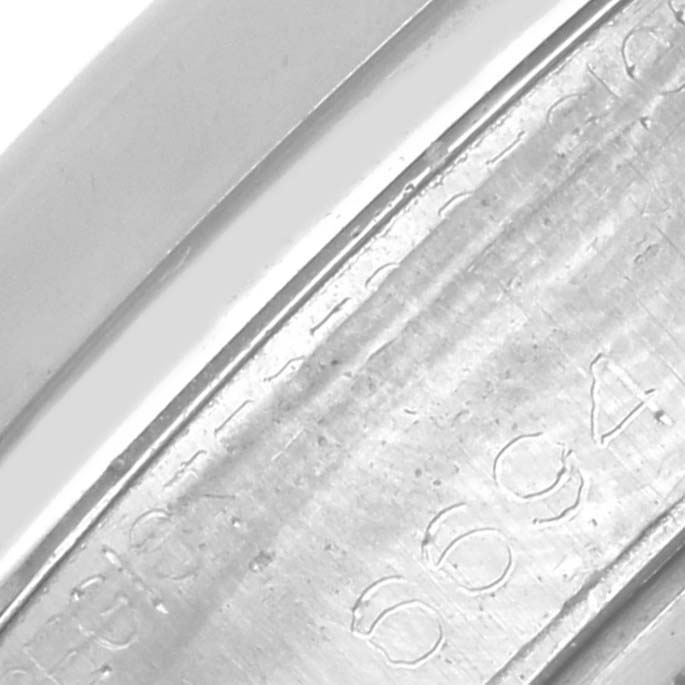 The image shows an extreme close-up of the inner case engraving on a Date model by Rolex at an angled view.
