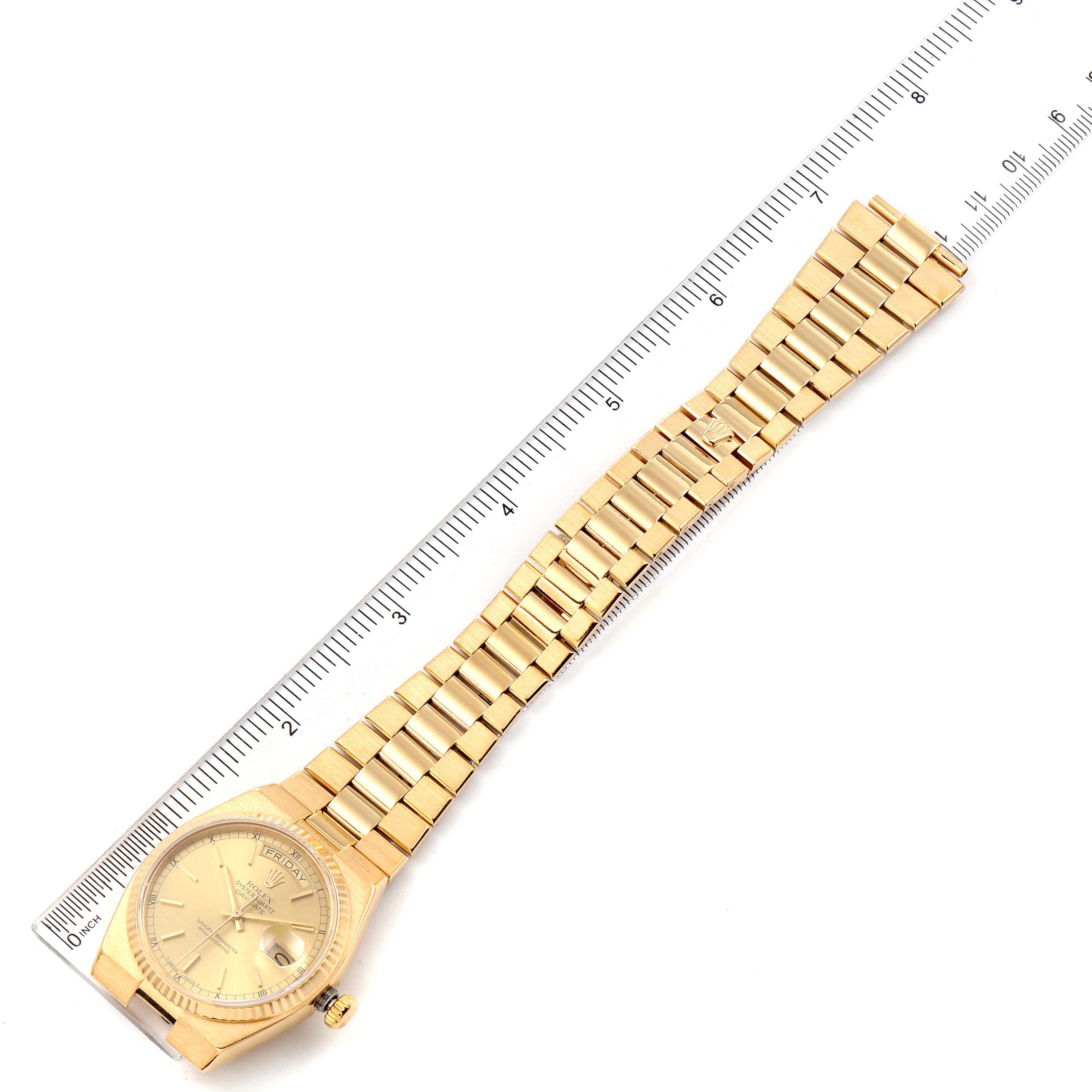 This image shows a Rolex Oysterquartz 19018 Men's Yellow Gold Champagne Dial 19018 Men's Yellow Gold Champagne Dial watch laid flat next to a ruler, displaying the entire bracelet and face.
