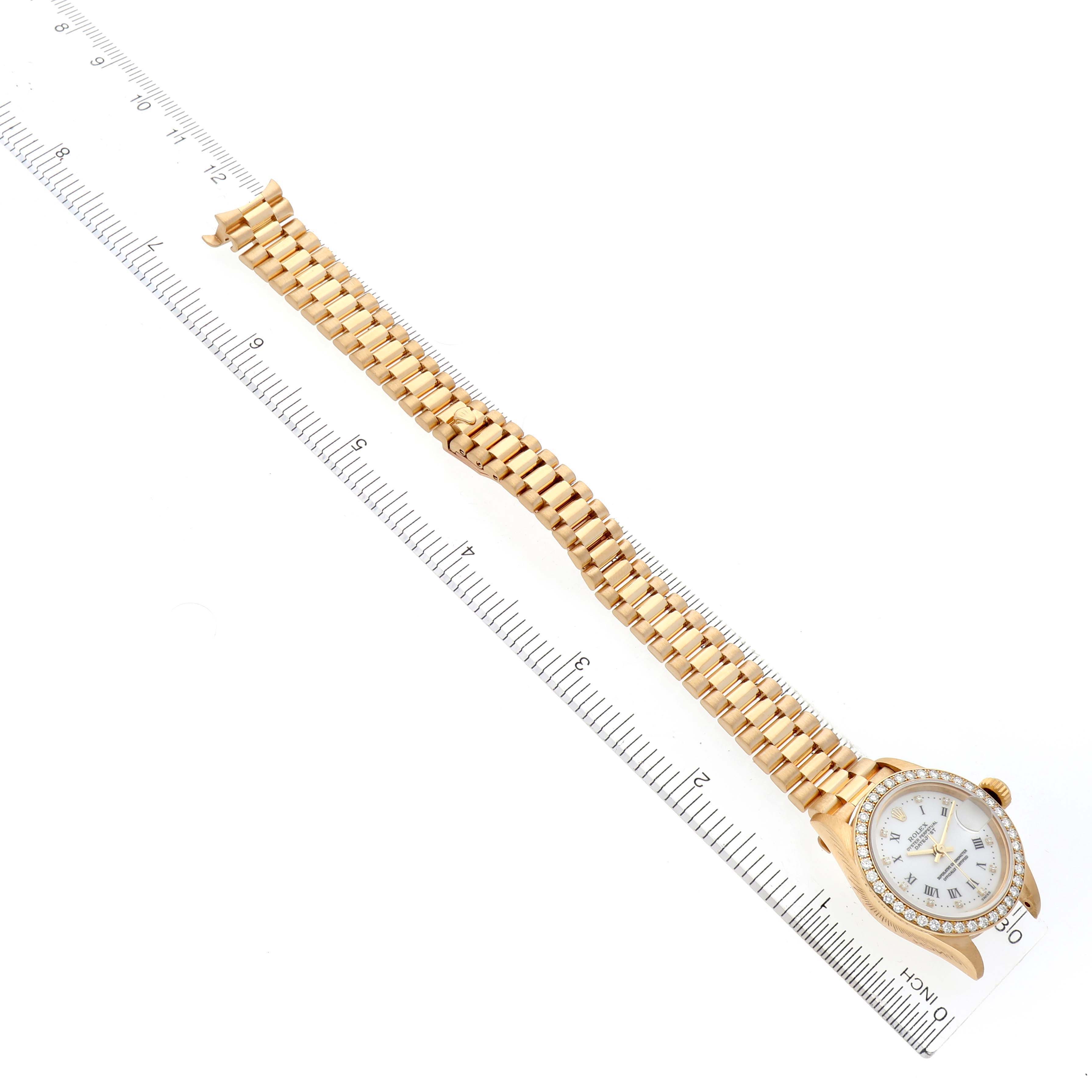 The Rolex President 79138 Women's Yellow Gold White Dial 79138 Women's Yellow Gold White Dial watch is shown from an angled top view, displaying the face, bezel, and full bracelet with a ruler next to it.