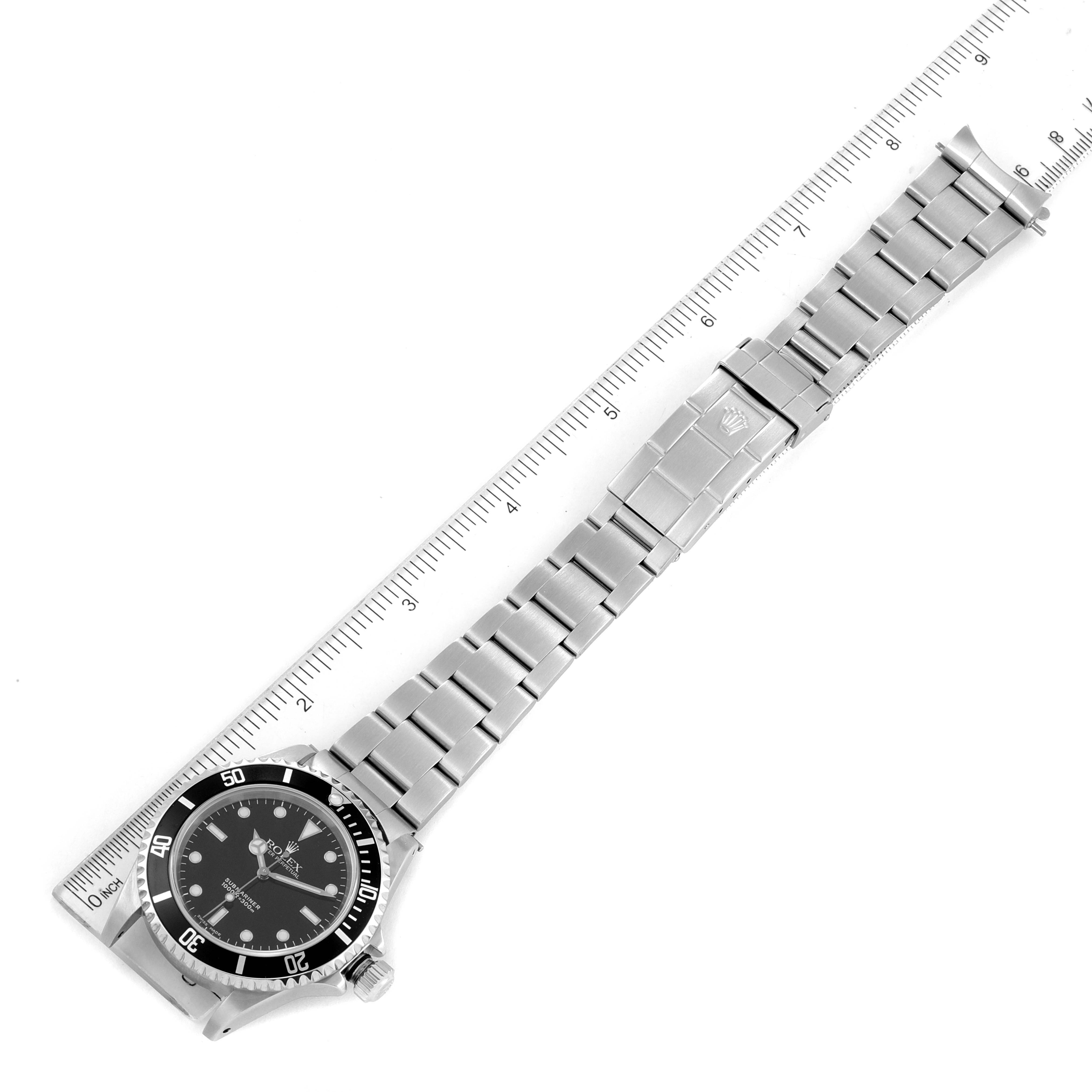 The image shows a top-down view of a Rolex Submariner 14060 Men
s Stainless Steel Black Dial 14060 Men
s Stainless Steel Black Dial watch with its measurement taken using a ruler.