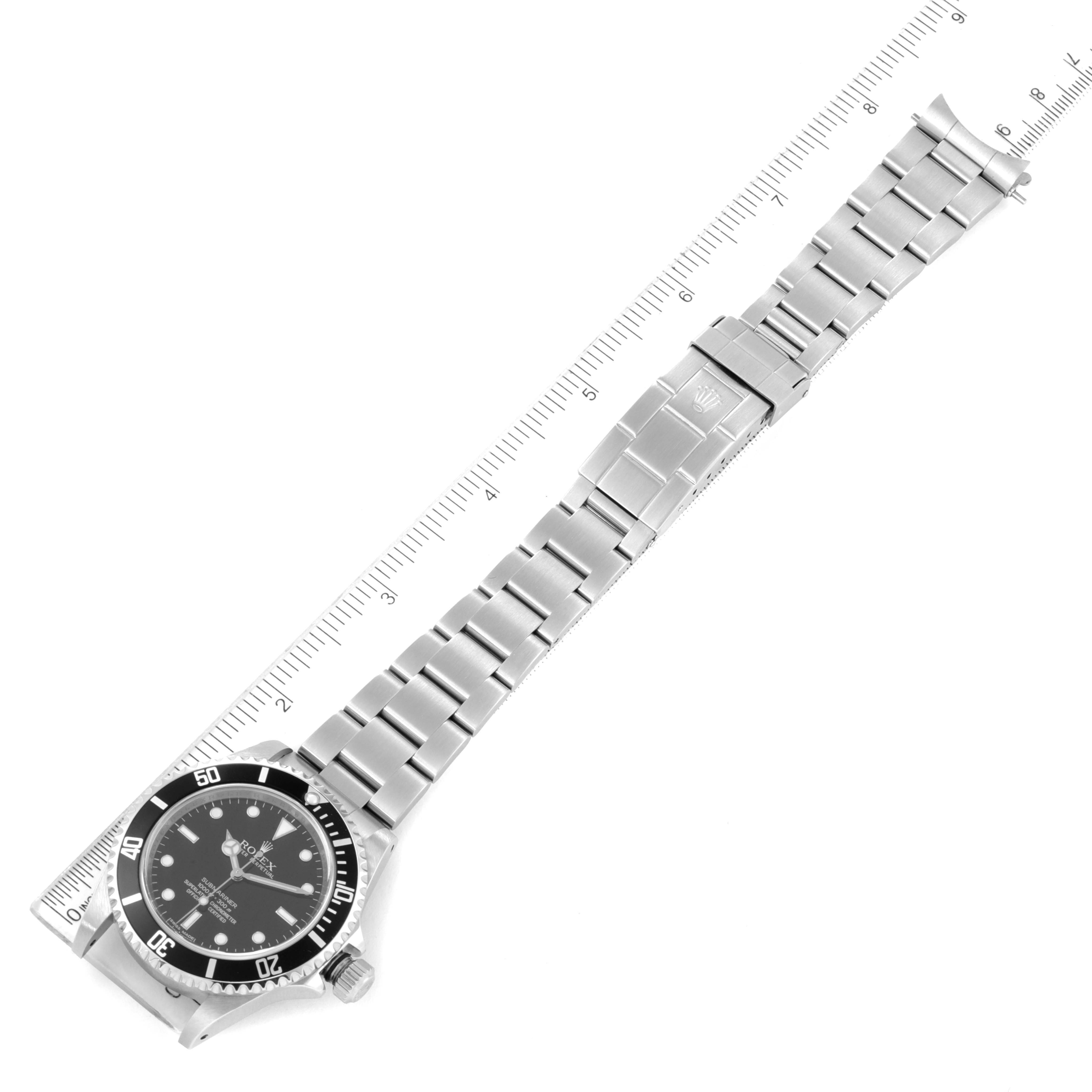 The image shows a side angle of a Rolex Submariner 14060 Men
s Stainless Steel Black Dial 14060 Men
s Stainless Steel Black Dial watch, displaying its face, bezel, and full metal bracelet with a clasp, positioned on a ruler.