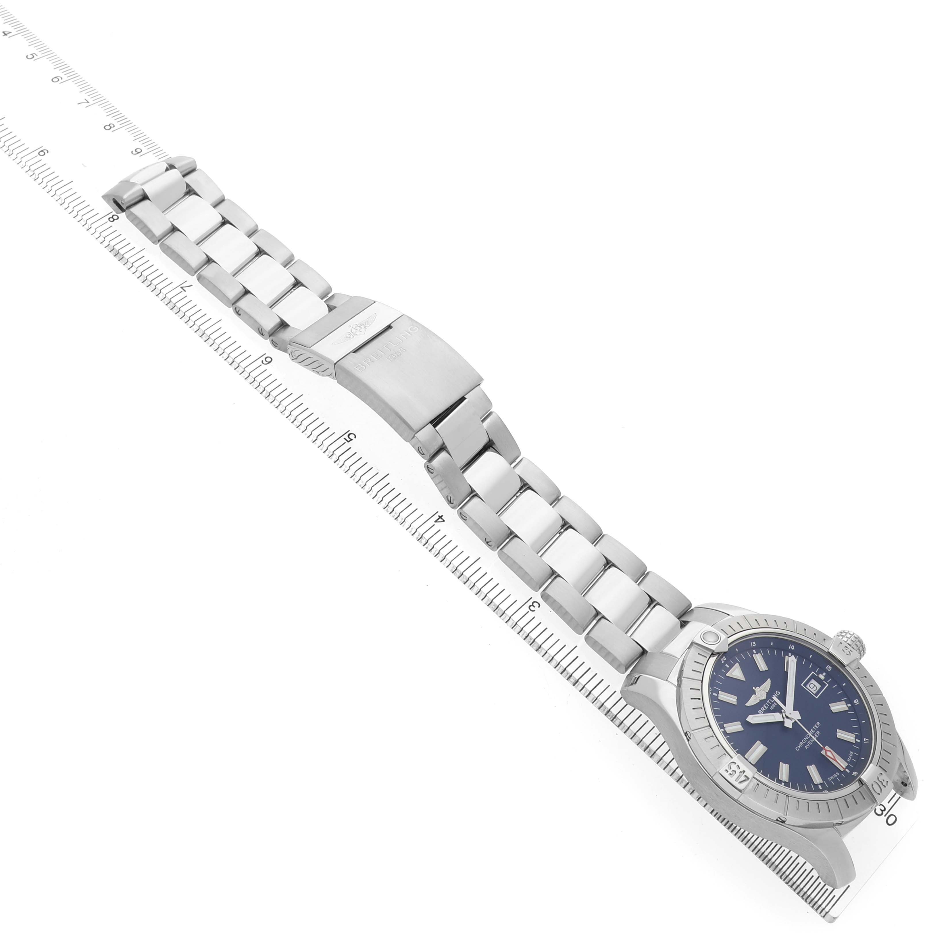 The Breitling Avenger A17318101C1A1 Men's Stainless Steel Blue Dial watch is shown at an angled side view, displaying the bracelet and face, with a ruler indicating length.