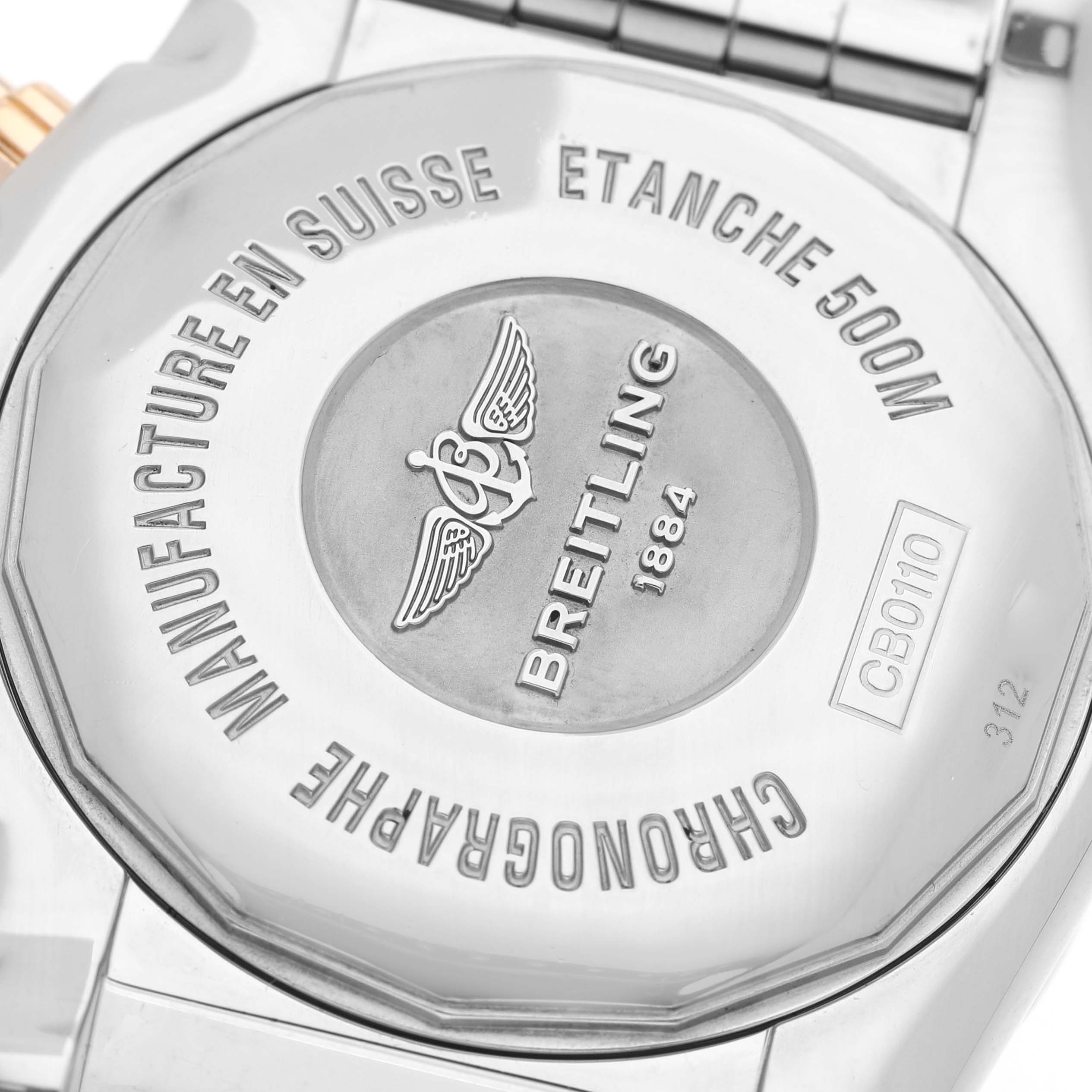 The image shows the backside of a Breitling Chronomat CB0110 Men's Steel and Gold (two tone) Blue Dial watch, highlighting the engraved details and branding.