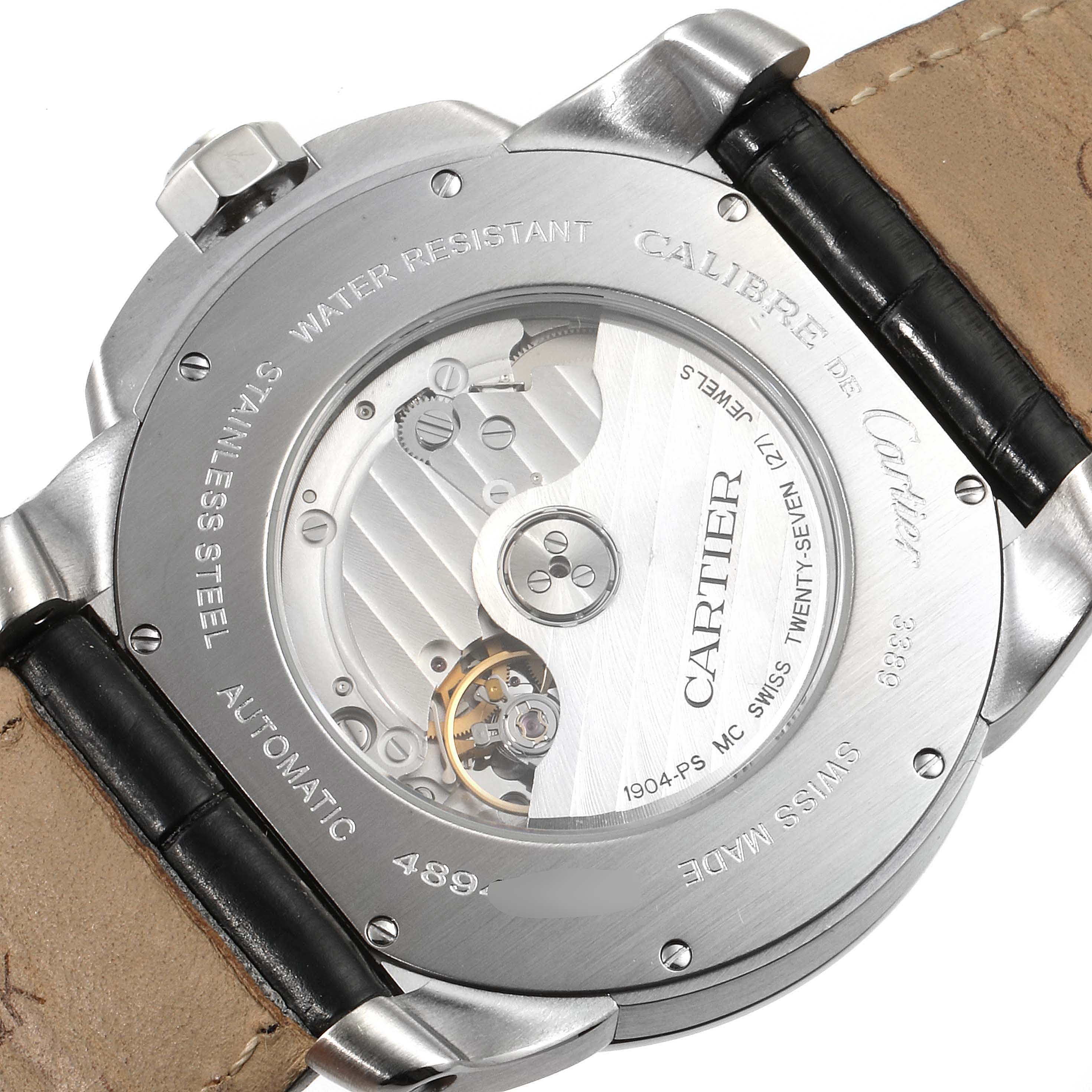 The image shows the back of the Calibre de Cartier watch, revealing the automatic movement and inscriptions.