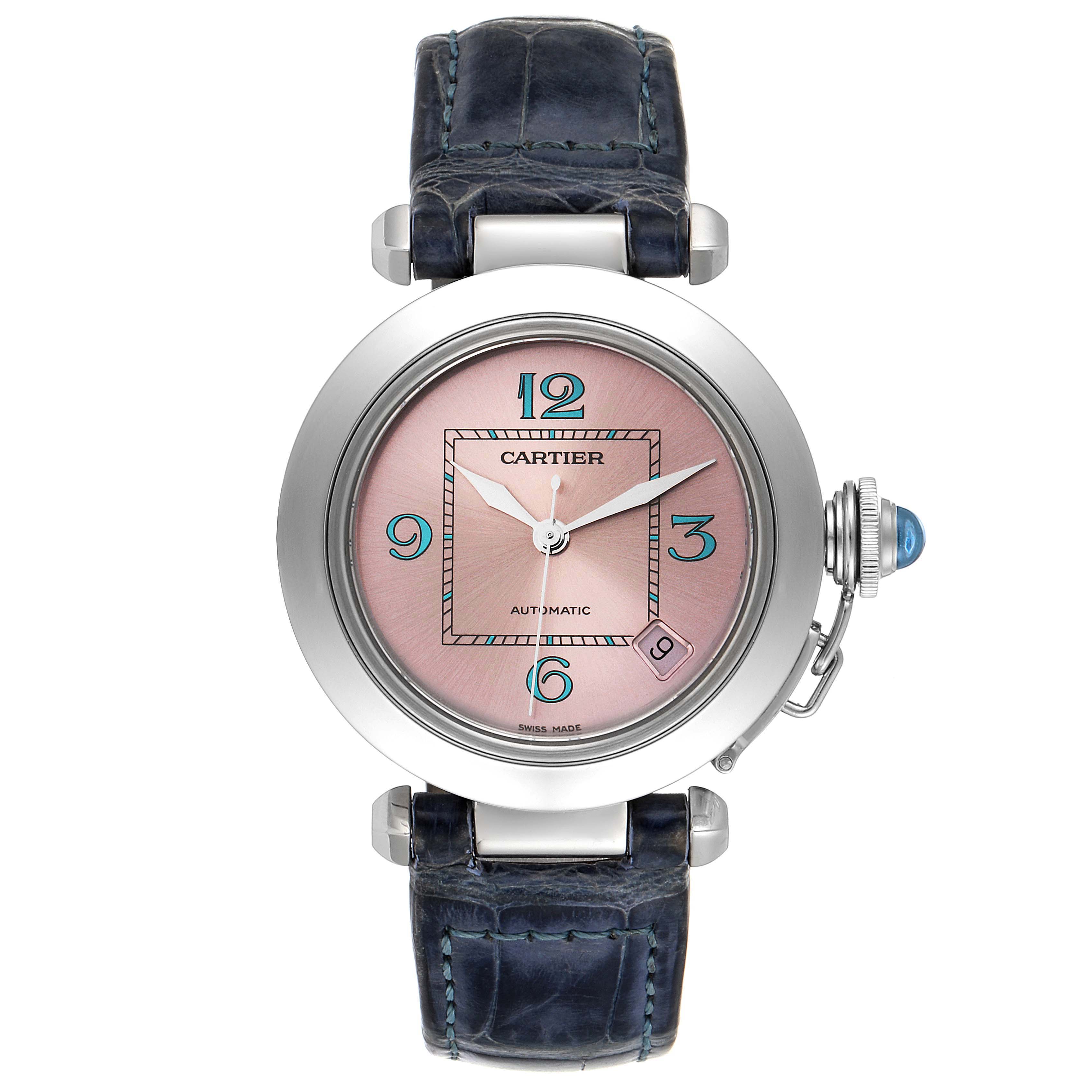 The image shows a frontal view of a Cartier Pasha W3108199 Women's Stainless Steel Pink Dial W3108199 Women's Stainless Steel Pink Dial watch, featuring a pink dial, blue numerals, and a blue leather strap.