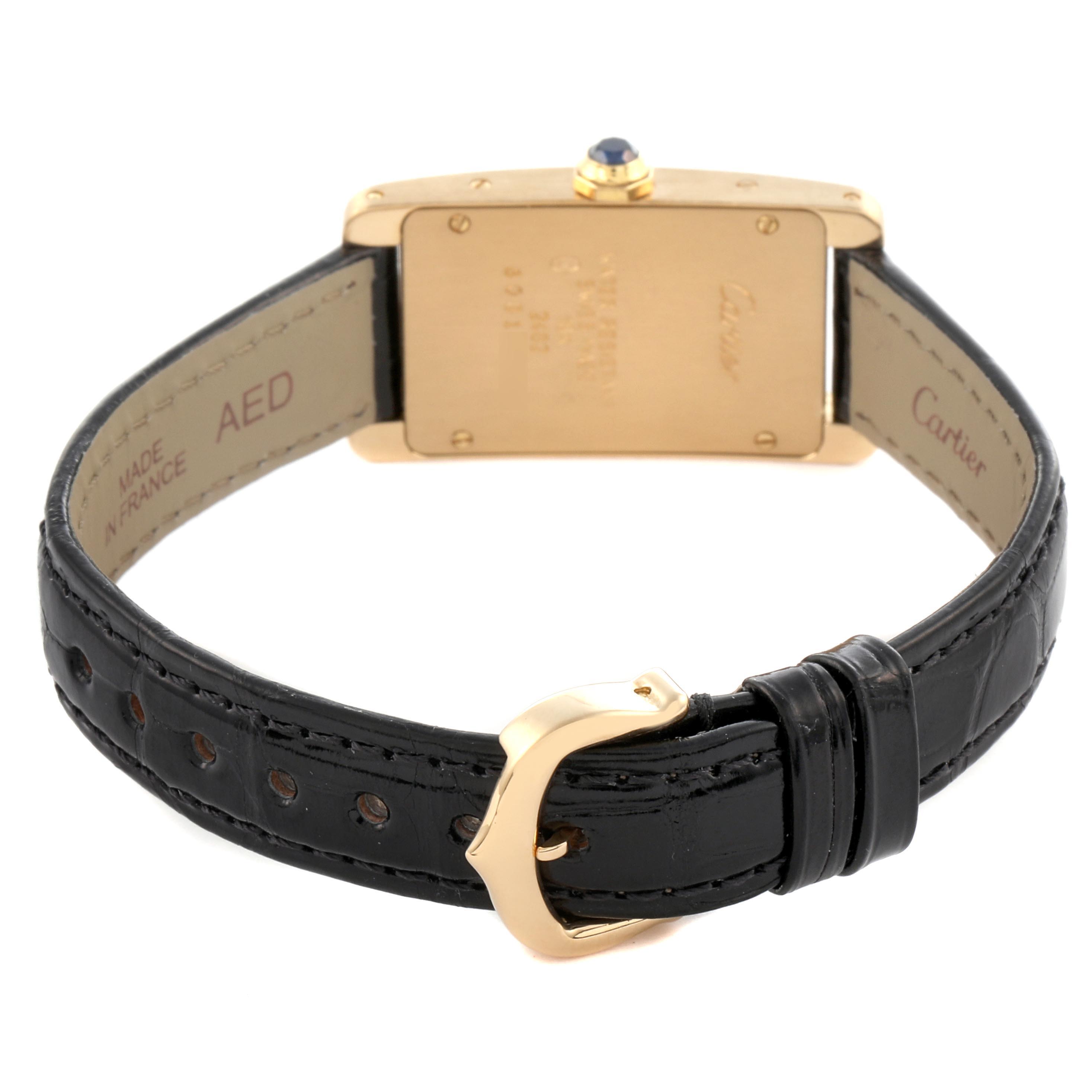 The image shows the back of a Cartier Tank Americaine W2601556 Women's Yellow Gold Silver Dial W2601556 Women's Yellow Gold Silver Dial watch, highlighting the gold buckle and black leather strap.