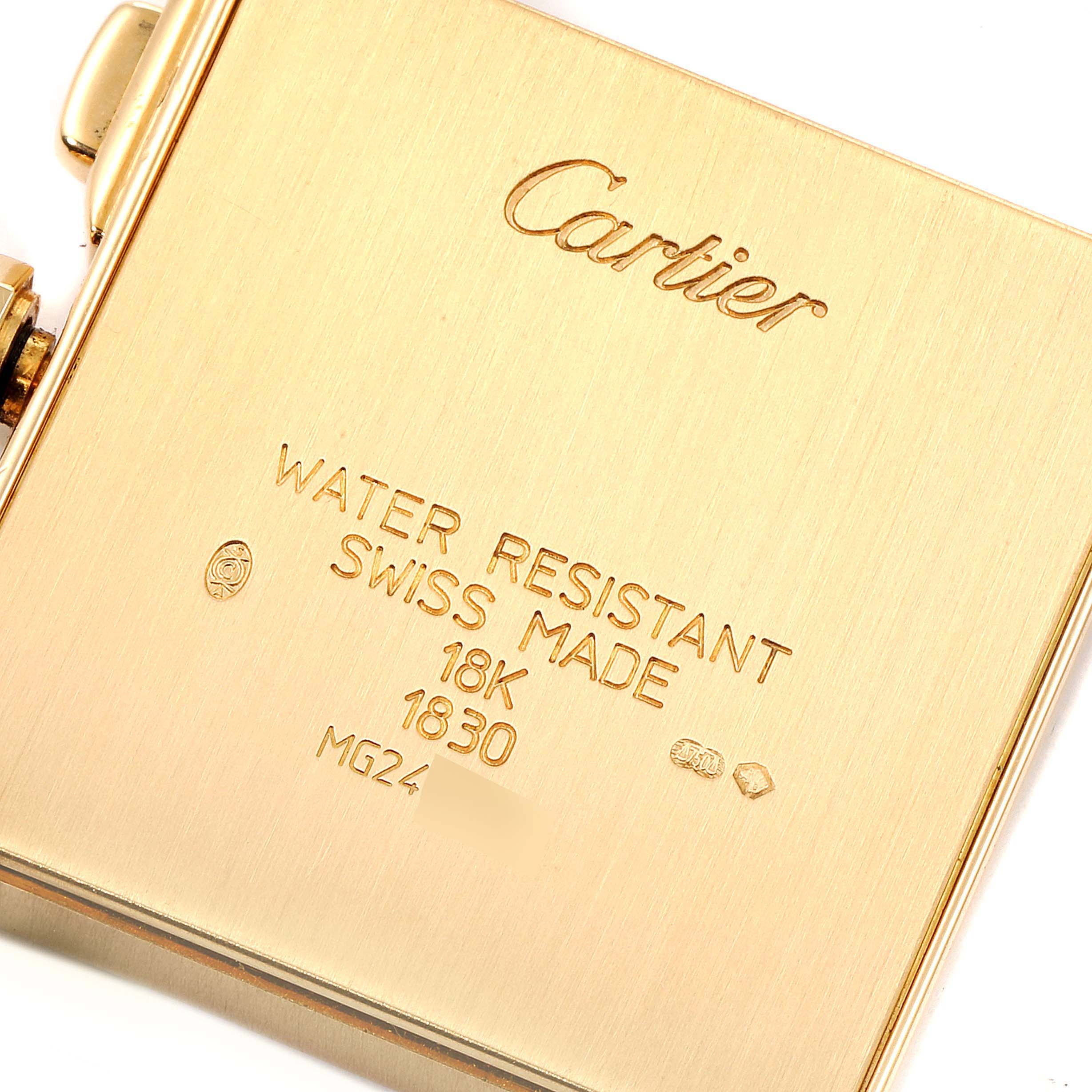The image shows the back case of a Cartier Tank Francaise W5000556 Men's Yellow Gold Silver Dial W5000556 Men's Yellow Gold Silver Dial watch, highlighting its inscriptions and gold material.