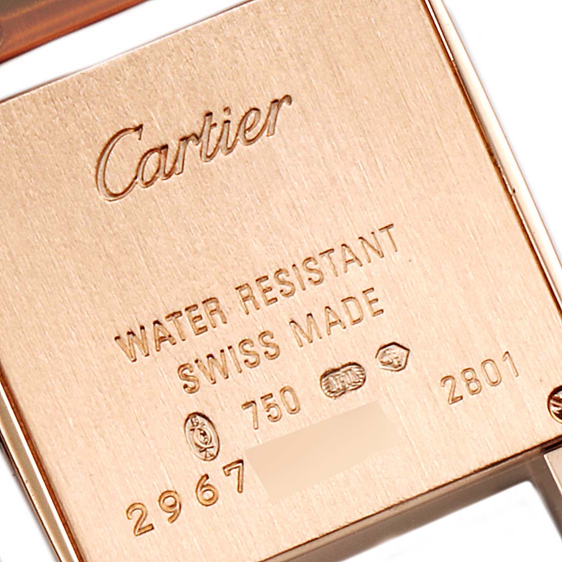 The image shows the back case of a Cartier Tank Française watch, highlighting its inscriptions and hallmark.