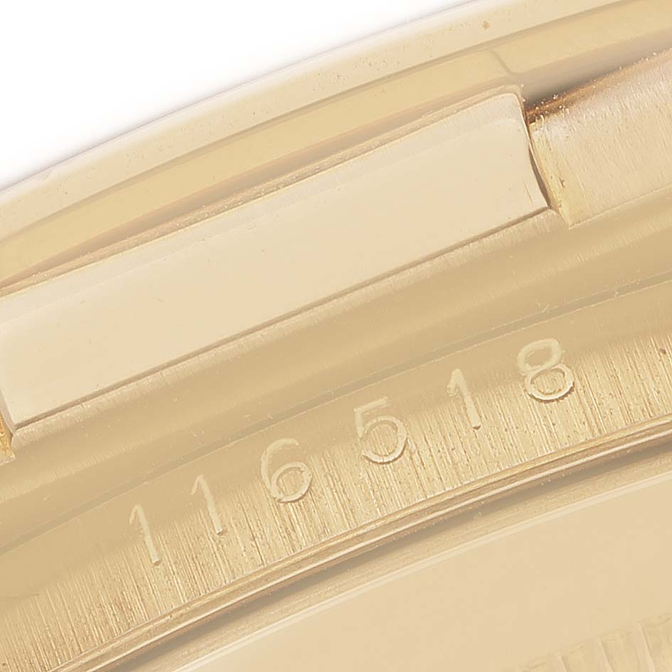 The image shows a close-up of the bezel and engraved model number "116518" of a Rolex Daytona 116518 Men's Yellow Gold Blue Dial watch.