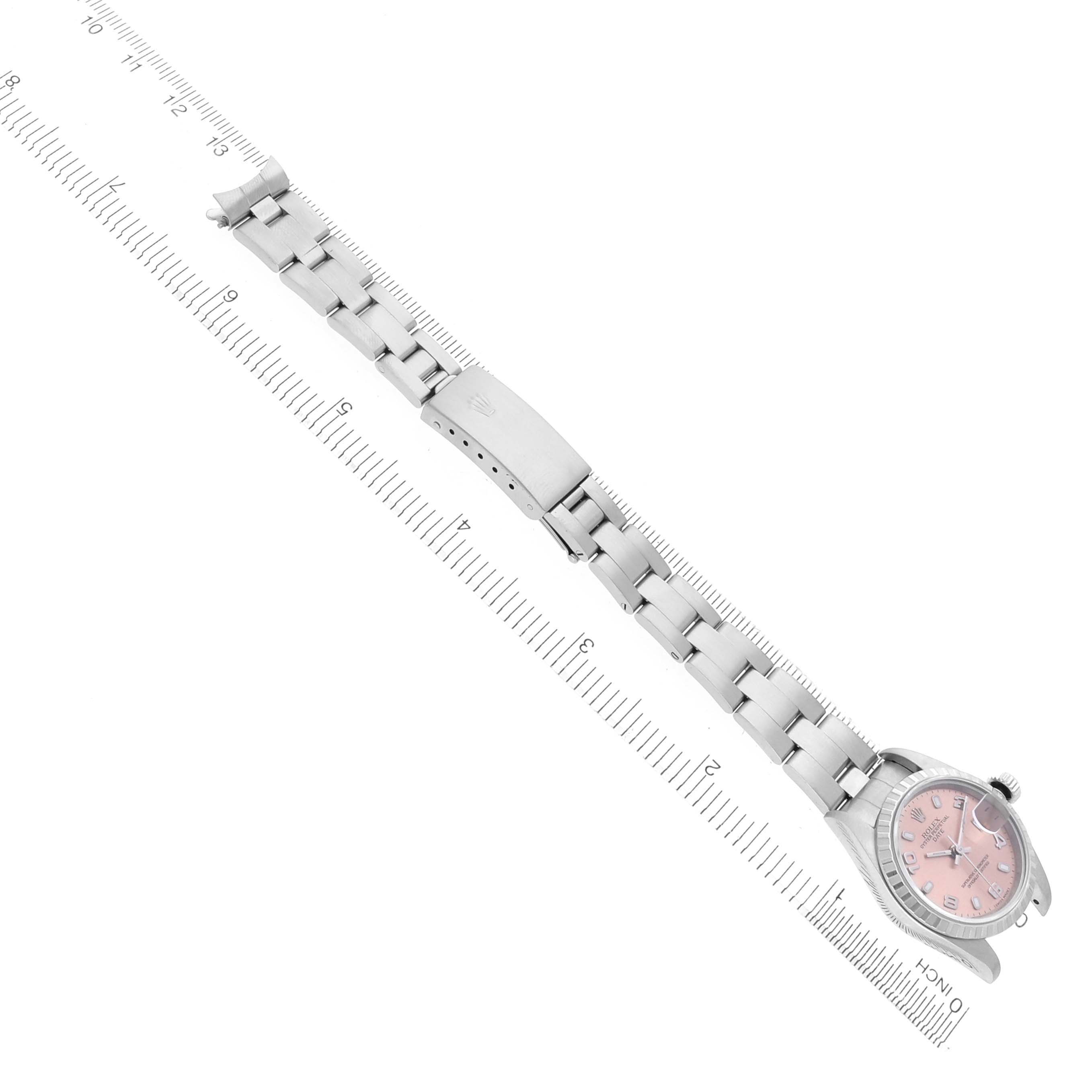 The Rolex Date 79240 Women's Stainless Steel Pink Dial 79240 Women's Stainless Steel Pink Dial model watch is shown from an angled top view, displaying the bracelet and face next to a ruler for scale.