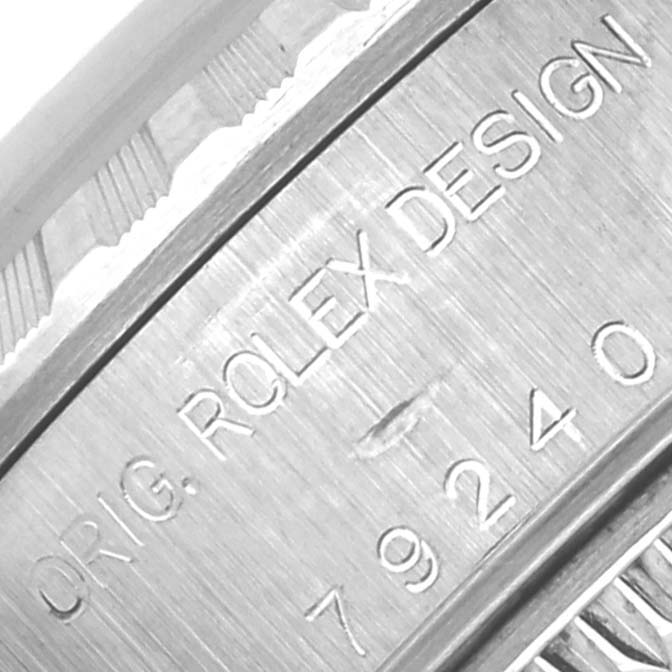 This image shows a close-up of the engraved serial number and text on the case of a Rolex Date 79240 Women's Stainless Steel Pink Dial 79240 Women's Stainless Steel Pink Dial watch.