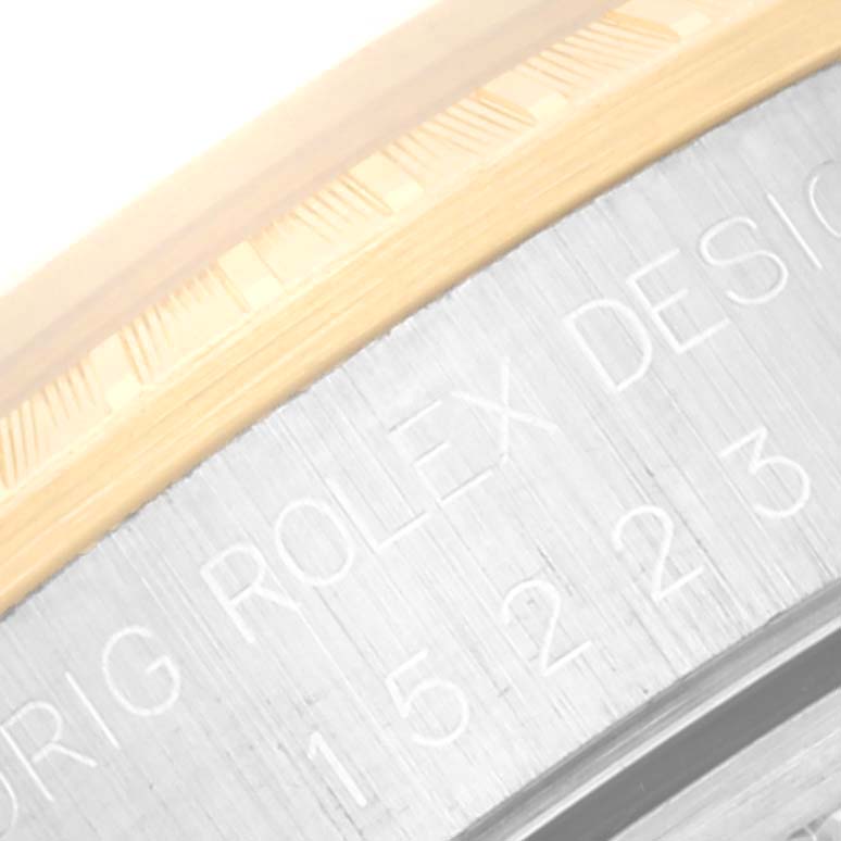 The image shows a close-up angle of the fluted bezel and part of the engraved case of a Rolex Date 15223 Men's Steel and Gold (two tone) Champagne Dial 15223 Men's Steel and Gold (two tone) Champagne Dial model watch.