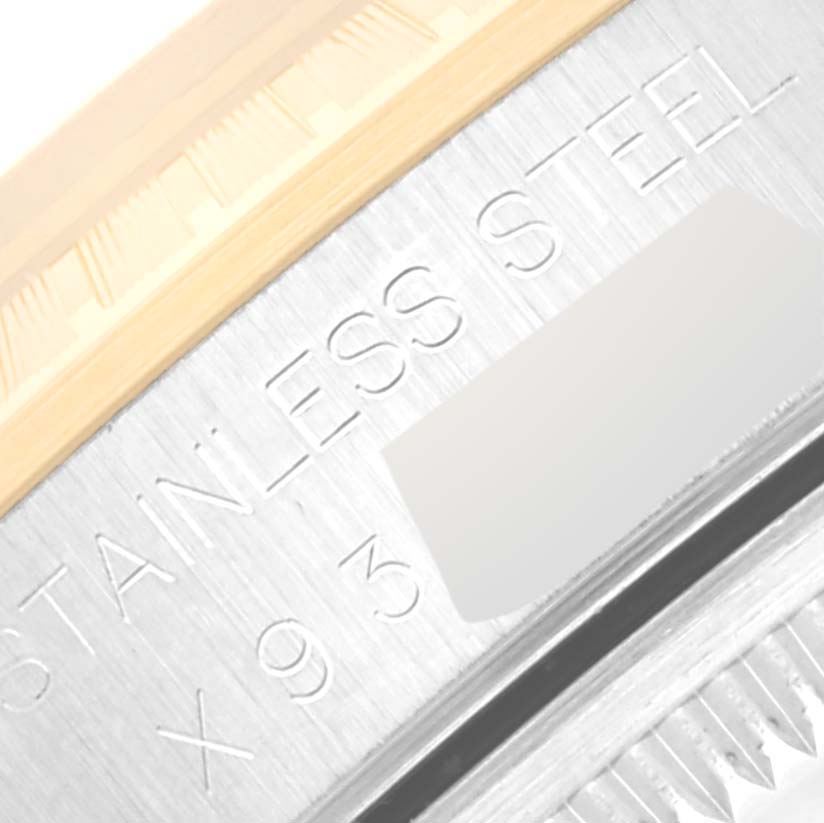 The image shows a close-up of the Rolex Date 15223 Men's Steel and Gold (two tone) Champagne Dial 15223 Men's Steel and Gold (two tone) Champagne Dial model watch, highlighting the edge of the case with "STAINLESS STEEL" engraving.