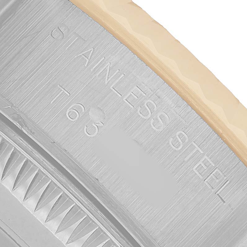 The image shows a close-up of the side of a Rolex Datejust 69173 Women's Steel and Gold (two tone) White Dial watch, highlighting the stainless steel case with engraved text.