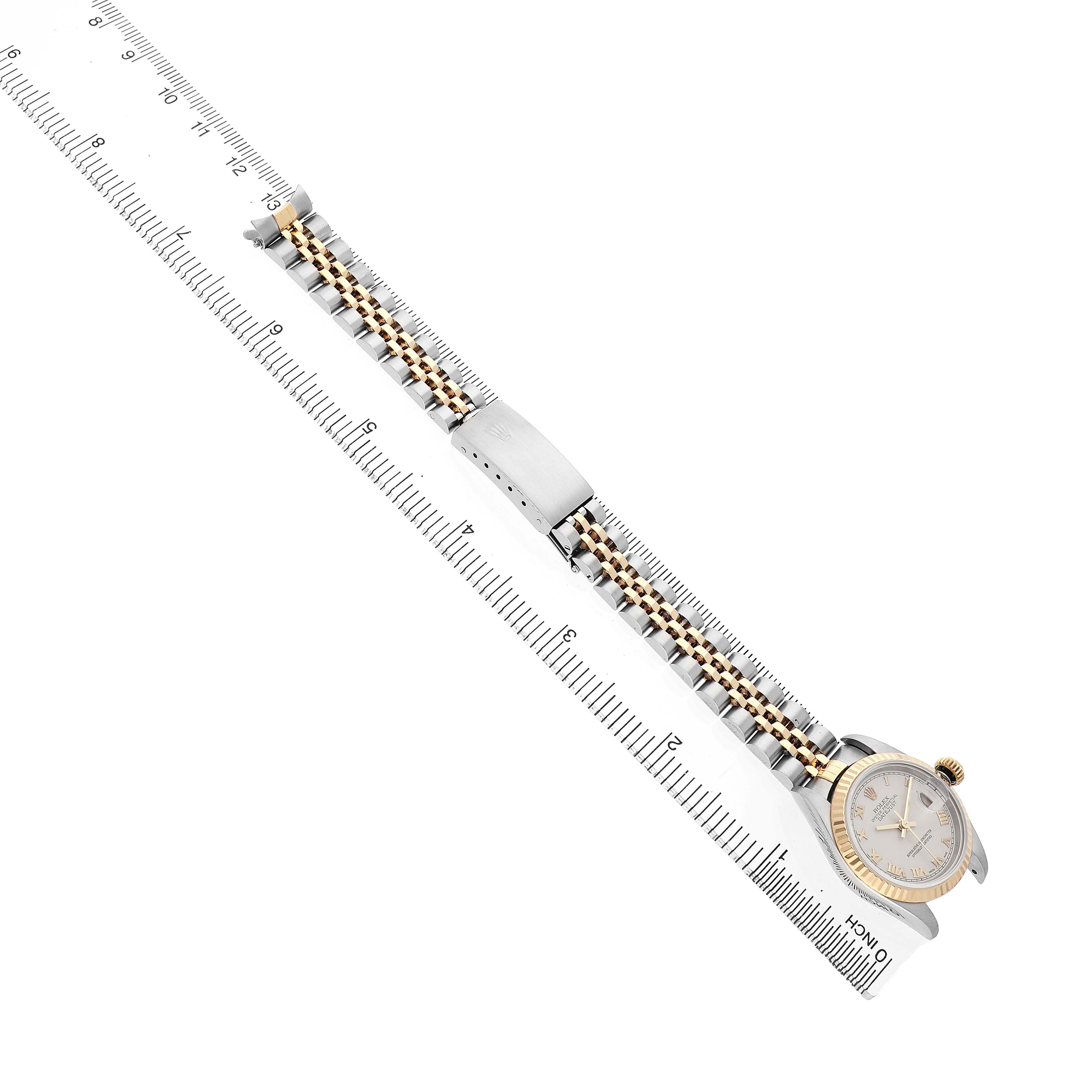 The image shows a Rolex Datejust 69173 Women's Steel and Gold (two tone) White Dial watch at a diagonal angle with a focus on the bracelet and clasp, alongside a ruler for scale.