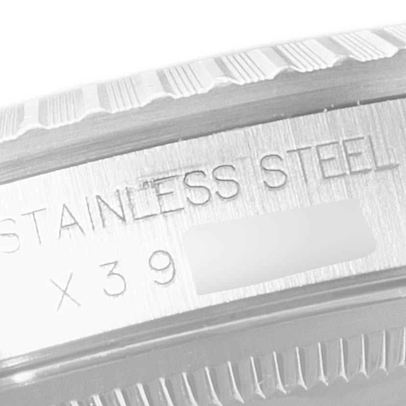 The image shows a close-up of the side of a Rolex Datejust 16220 Men
s Stainless Steel Black Dial 16220 Men
s Stainless Steel Black Dial
s stainless steel case with visible engraved text and a portion of the bezel.