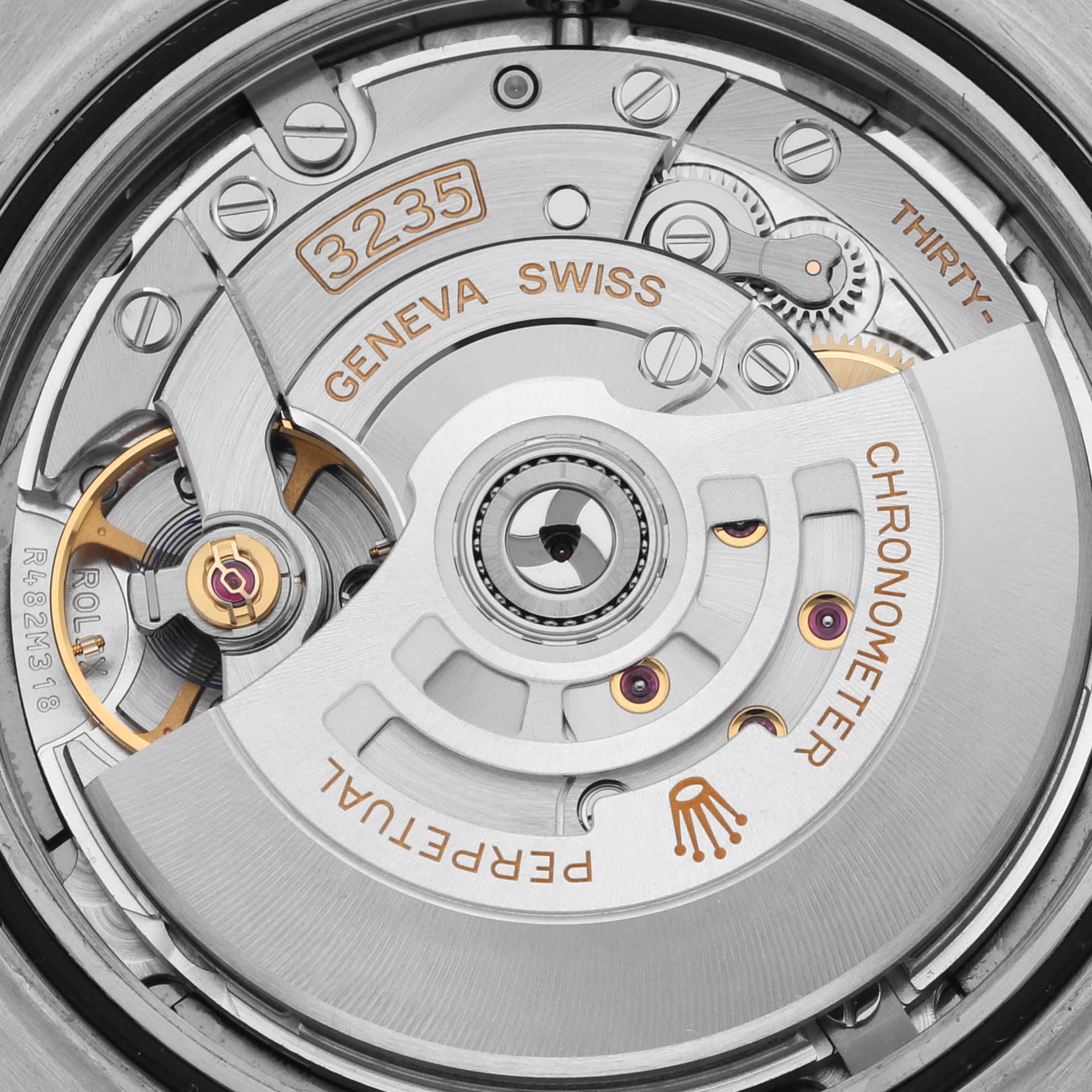 The image shows a close-up of the movement mechanism of a Rolex Datejust 41 126333 Men's Steel and Gold (two tone) Grey Dial 126333 Men's Steel and Gold (two tone) Grey Dial, focusing on gears and inscriptions.