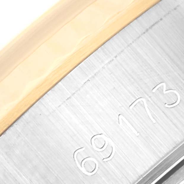 This close-up image shows a portion of the case with engraved numbers of a Rolex Datejust 69173 Women's Steel and Gold (two tone) Champagne Dial 69173 Women's Steel and Gold (two tone) Champagne Dial watch.