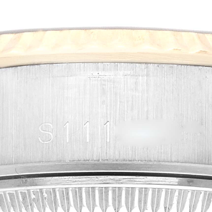 This image shows a close-up of the edge of a Rolex Datejust 69173 Women's Steel and Gold (two tone) Champagne Dial 69173 Women's Steel and Gold (two tone) Champagne Dial watch, highlighting the serial number on the side and the edge of the bezel.