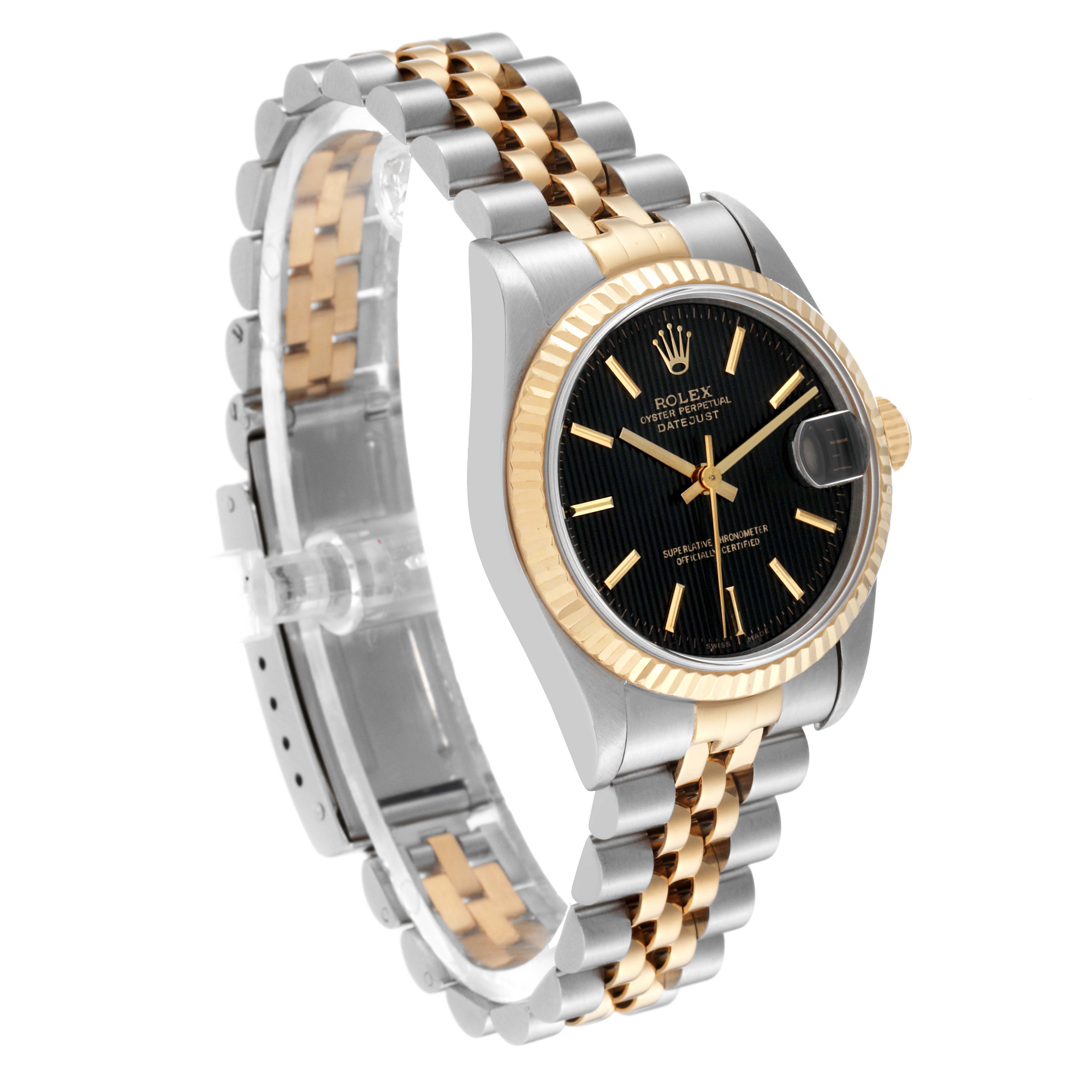 This image shows a Rolex Mid-Size 68273 Women's Steel and Gold (two tone) Black Dial 68273 Women's Steel and Gold (two tone) Black Dial Datejust watch at a three-quarter angle, highlighting the black dial, fluted bezel, and two-tone bracelet.