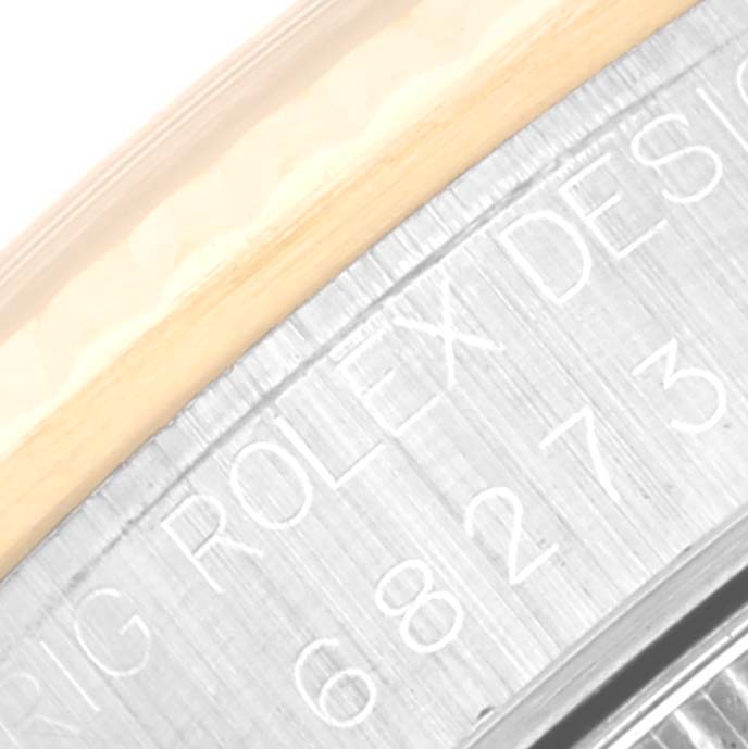 This close-up image shows the engraved side of a Mid-Size Rolex watch case, highlighting the words "ROLEX DESIGN" and part of the model number.