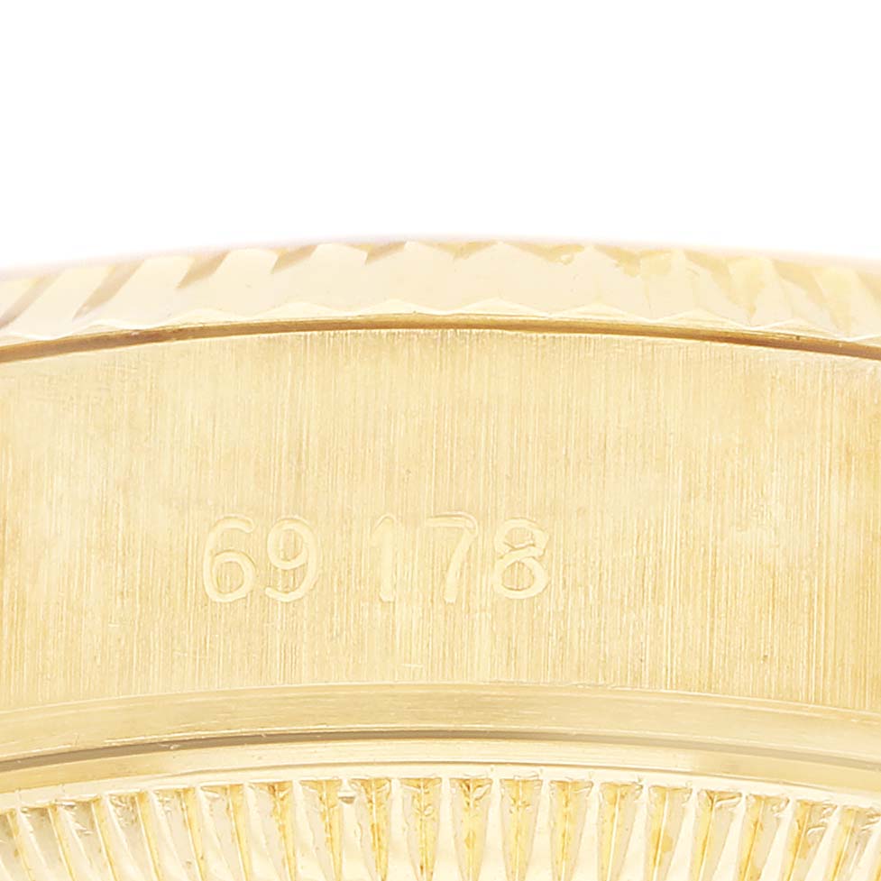The image shows a close-up of the engraved side of the Rolex President 69178 Women's Yellow Gold White Dial watch case, featuring model number details.