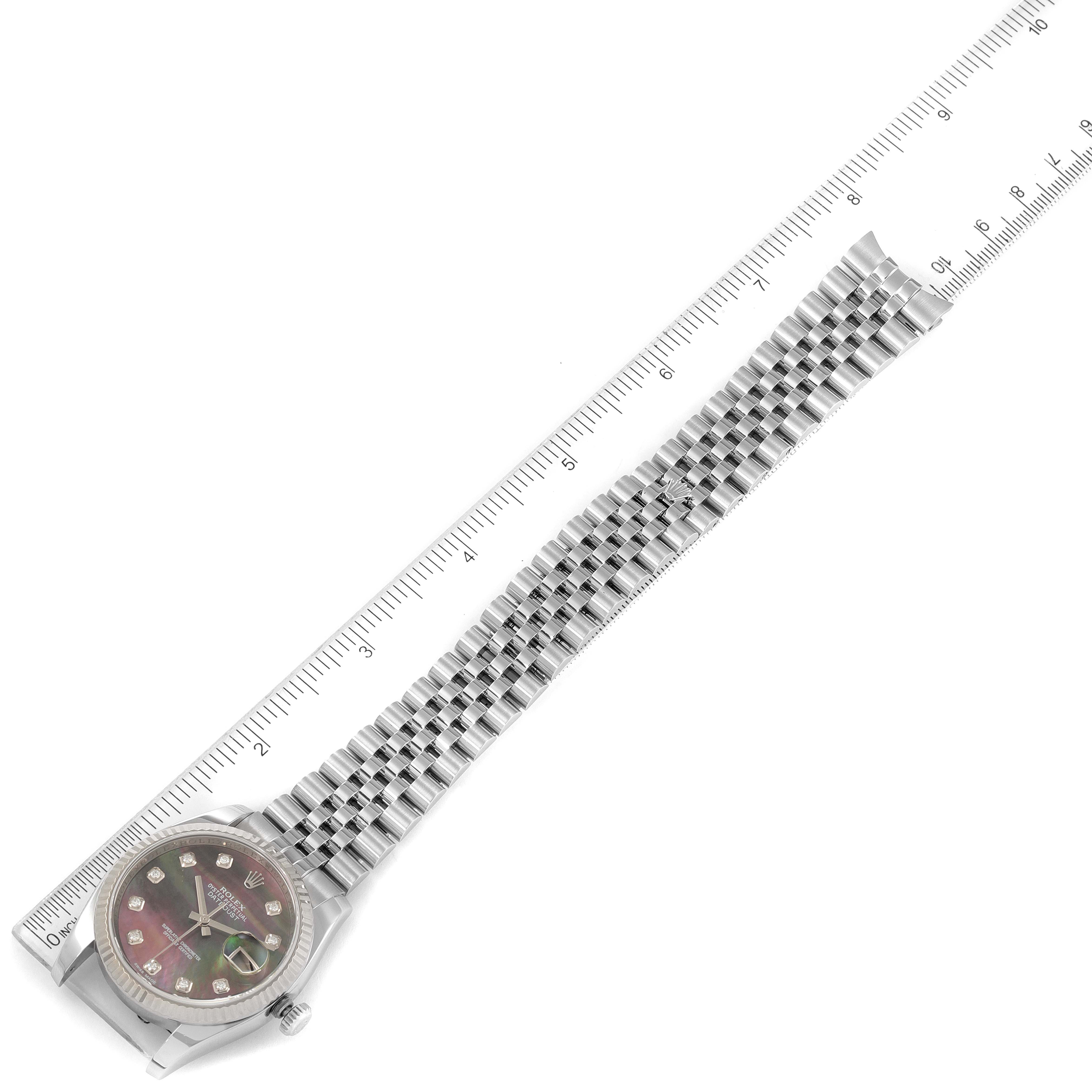 The Rolex Datejust 116234 Men's Stainless Steel Mother of Pearl Dial 116234 Men's Stainless Steel Mother of Pearl Dial watch is shown from above, displaying the entire watch including the face, case, and bracelet, with a ruler for scale.
