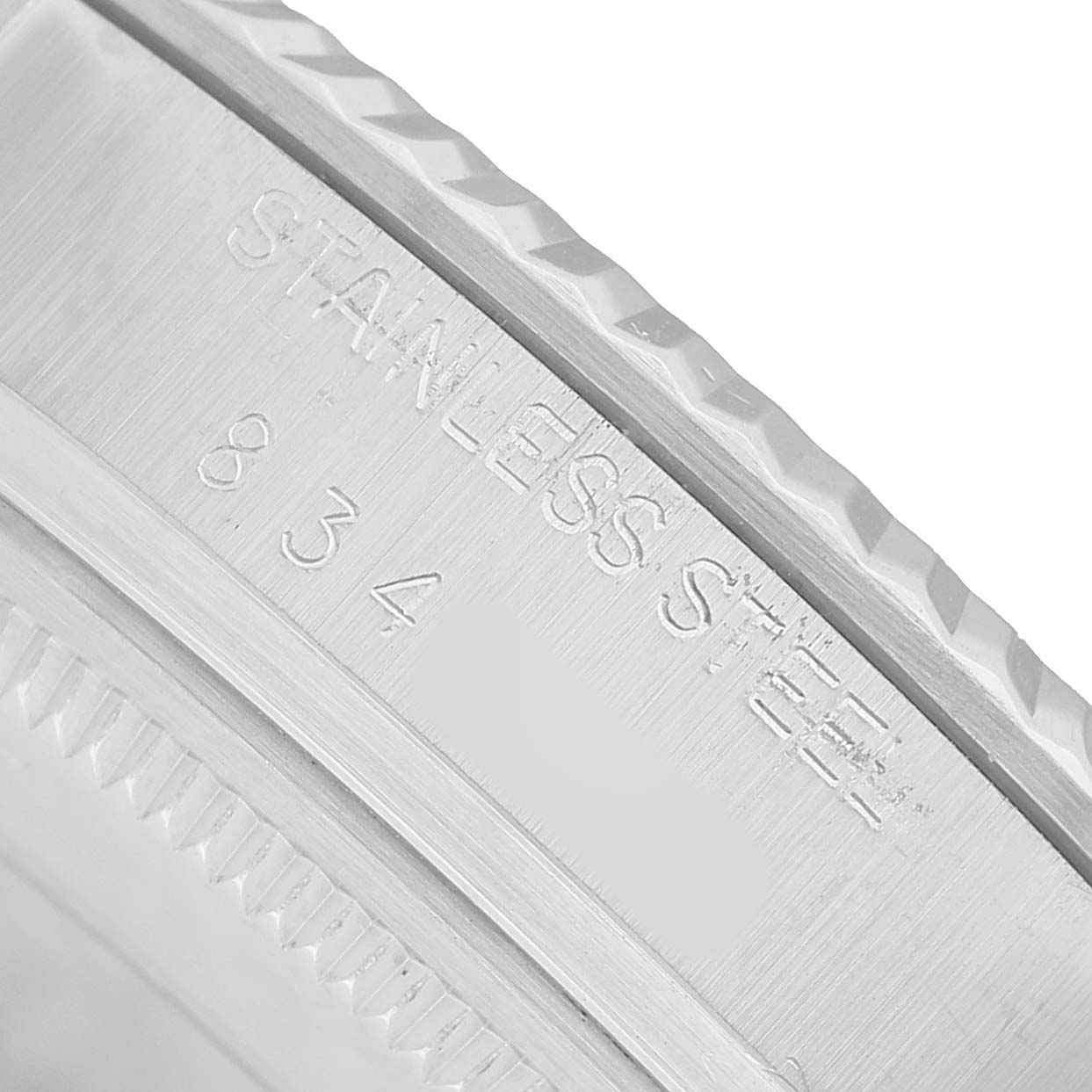 The image shows a close-up of the side of a Rolex Datejust 16014 Men's Stainless Steel Silver Dial watch, focusing on the engraved "STAINLESS STEEL" marking.