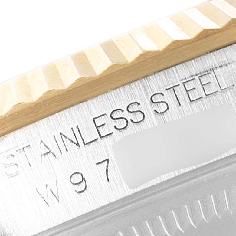 This image shows a close-up of a part of the engraved case back and fluted bezel of a Rolex Datejust 16233 Men's Steel and Gold (two tone) Champagne Dial 16233 Men's Steel and Gold (two tone) Champagne Dial watch in stainless steel.