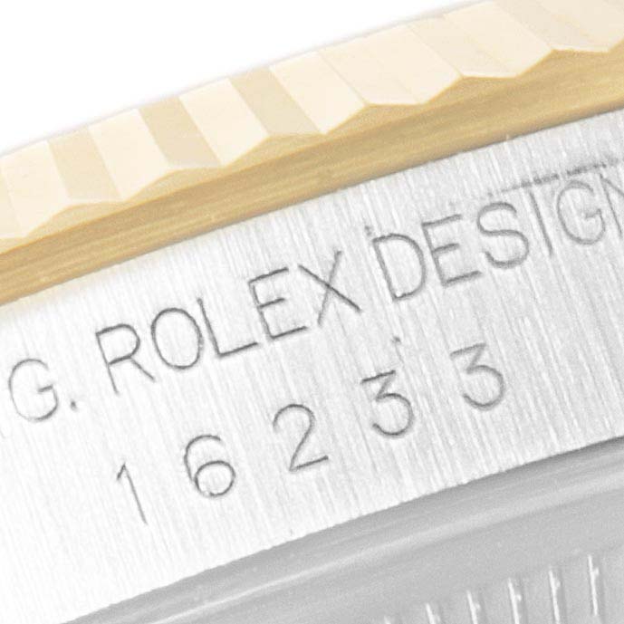 The image shows a close-up of the engraved serial number and the fluted bezel of a Rolex Datejust 16233 Men's Steel and Gold (two tone) Champagne Dial 16233 Men's Steel and Gold (two tone) Champagne Dial watch.
