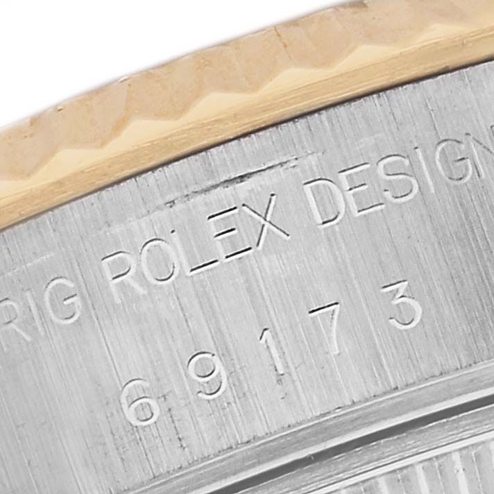 This close-up image of the Rolex Datejust 69173 Women's Steel and Gold (two tone) White Dial 69173 Women's Steel and Gold (two tone) White Dial shows part of the bezel and case with engraved text and model number "69173".