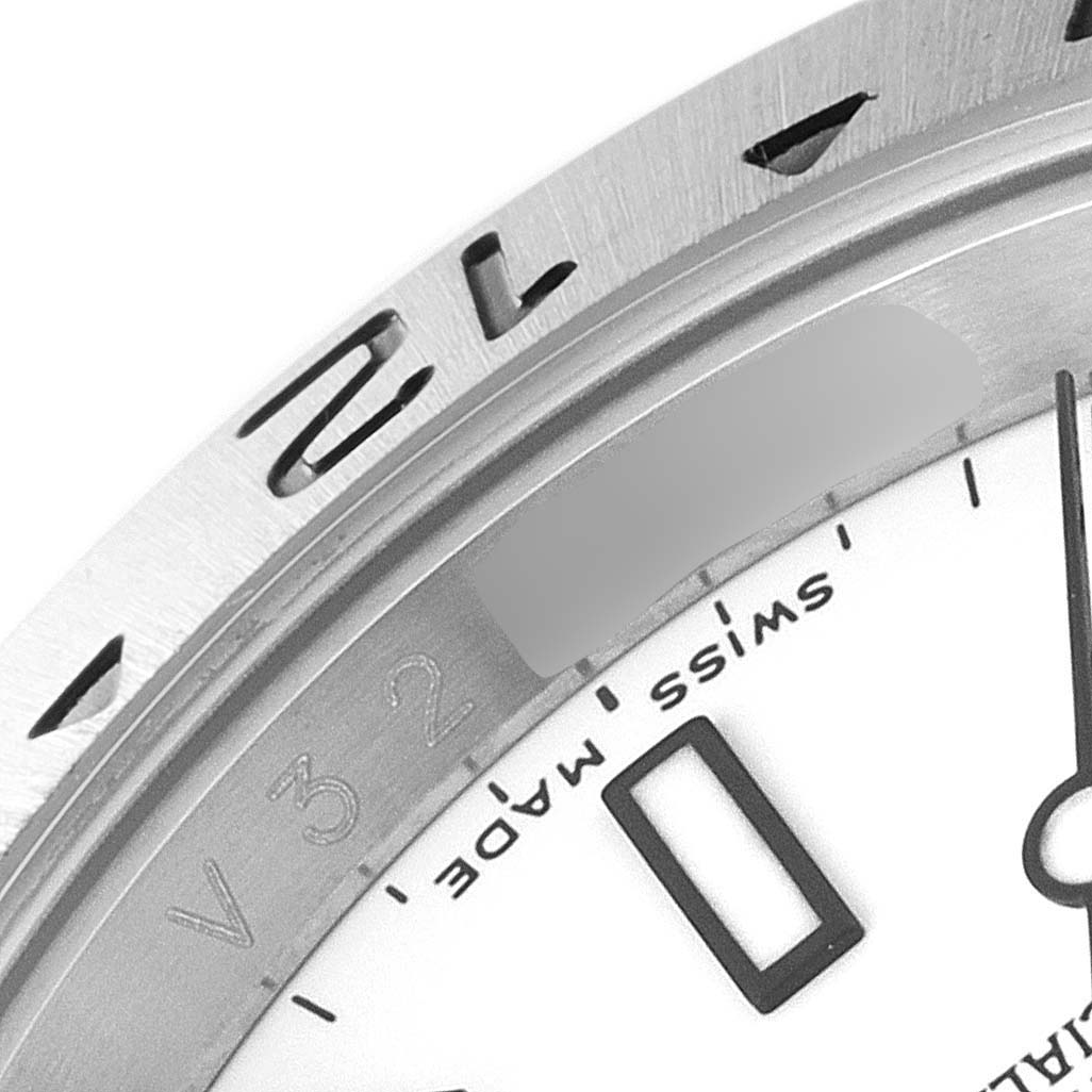The image shows a close-up of the bezel and part of the dial of a Rolex Explorer 16570 Men's Stainless Steel White Dial 16570 Men's Stainless Steel White Dial watch.
