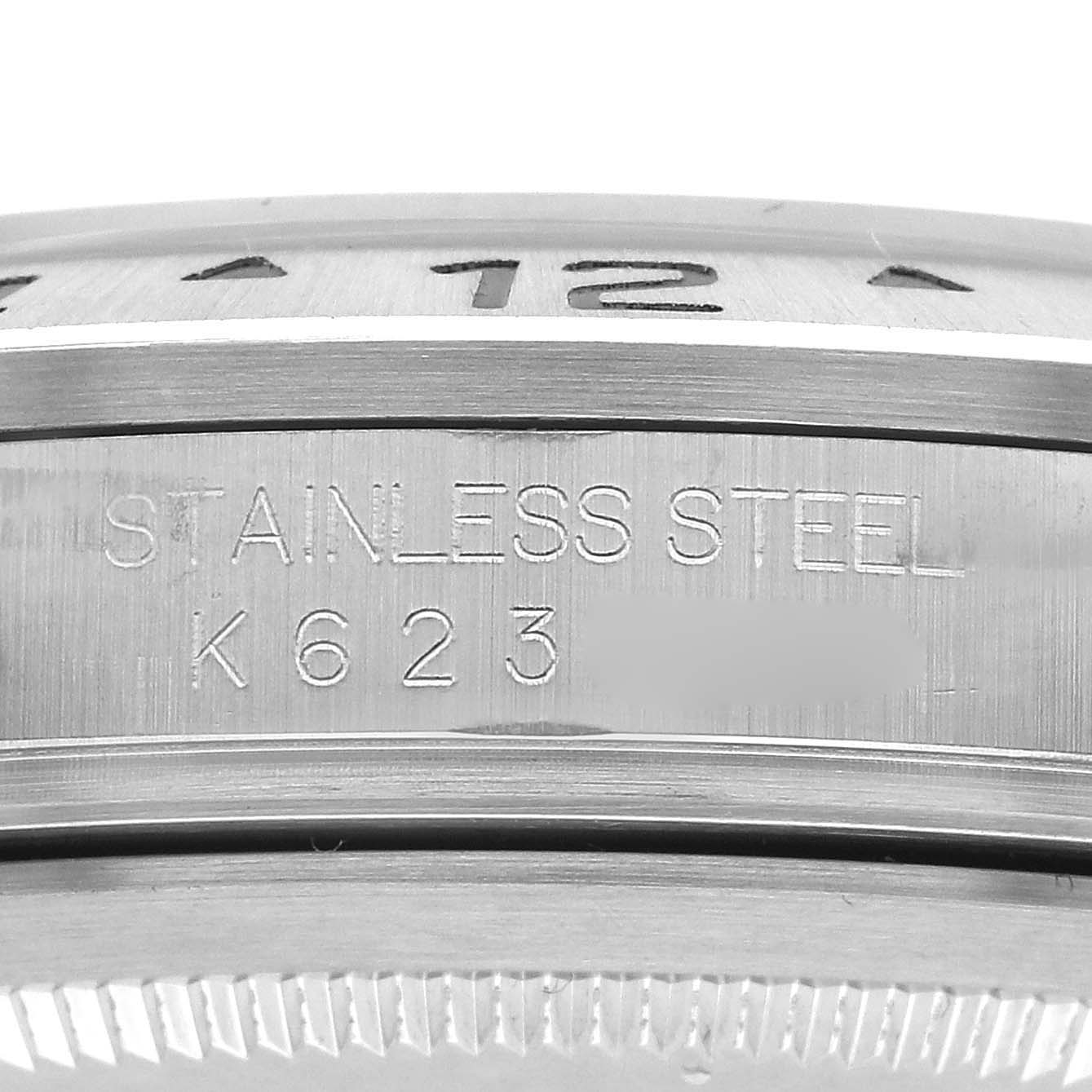 The image shows a close-up of the side of a Rolex Explorer 16570 Men's Stainless Steel White Dial 16570 Men's Stainless Steel White Dial watch, focusing on its stainless steel bezel with engraved numbers.