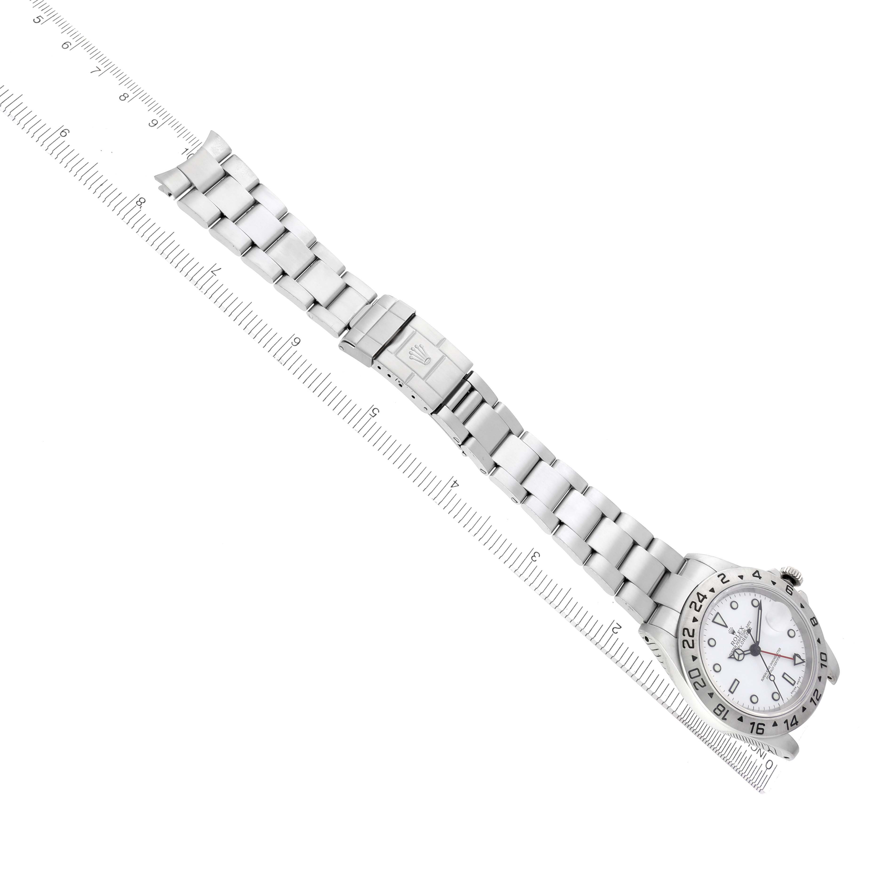 The Rolex Explorer 16570 Men's Stainless Steel White Dial 16570 Men's Stainless Steel White Dial watch is shown from a top view, displaying the full metal bracelet and clasp alongside a ruler for scale.