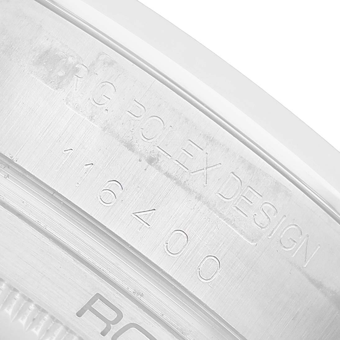 The image shows a close-up angle of a Rolex Milgauss 116400 Men's Stainless Steel White Dial model's engraved case edge, featuring the model number and brand.