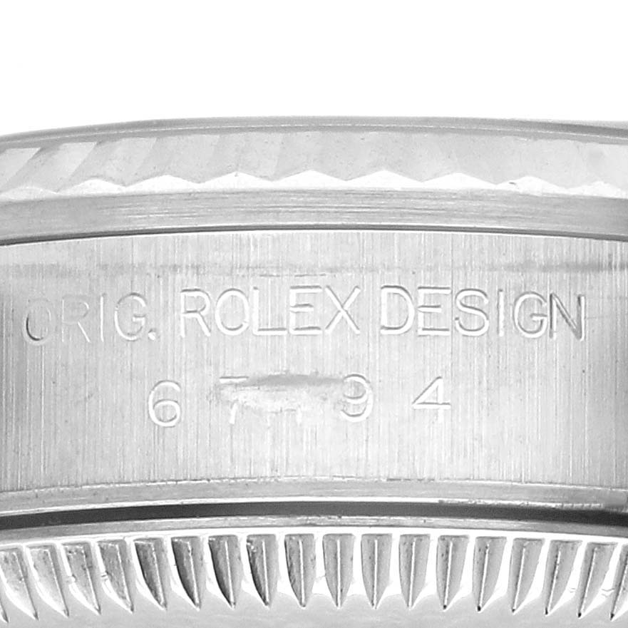 The image shows a close-up of the engraved side of the Oyster Perpetual Rolex watch case, highlighting the texture.