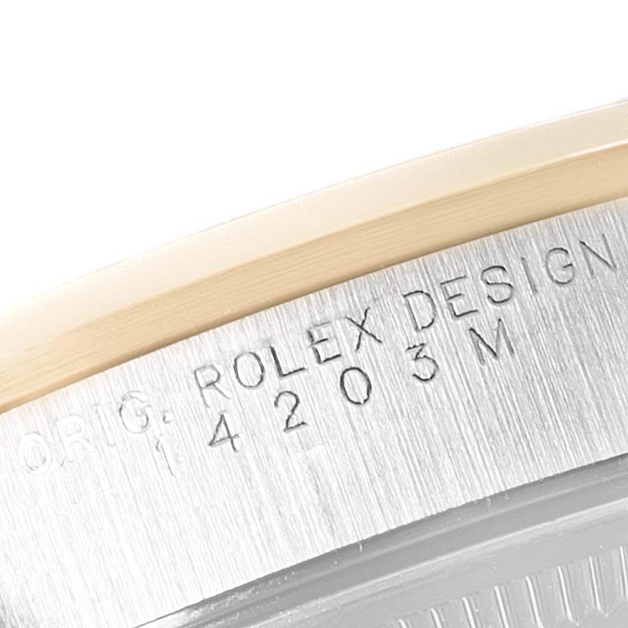 The image shows a close-up of the serial engraving on the caseback edge of a Rolex Oyster Perpetual 14203M Men's Steel and Gold (two tone) Grey Dial 14203M Men's Steel and Gold (two tone) Grey Dial watch.