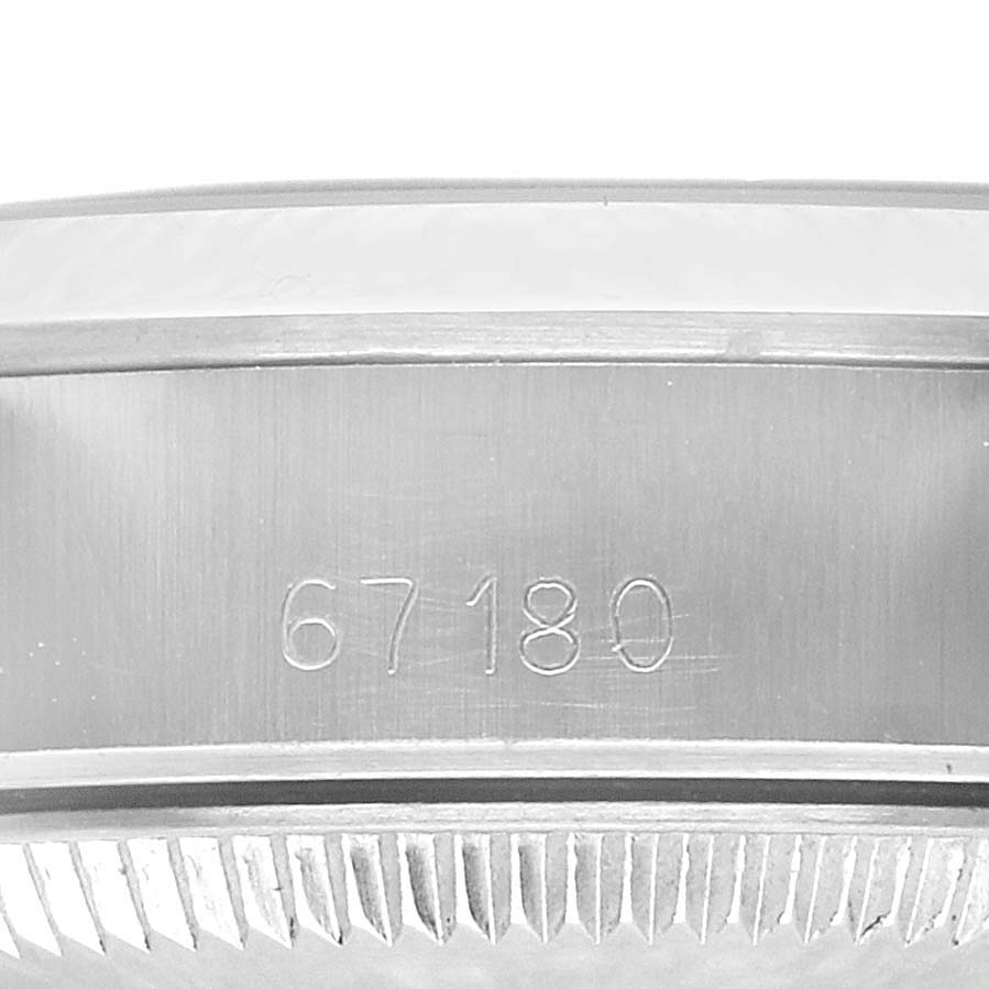 The image shows a close-up of the side of a Rolex Oyster Perpetual 67180 Women's Stainless Steel White Dial 67180 Women's Stainless Steel White Dial watch case, focusing on engraved numbers.