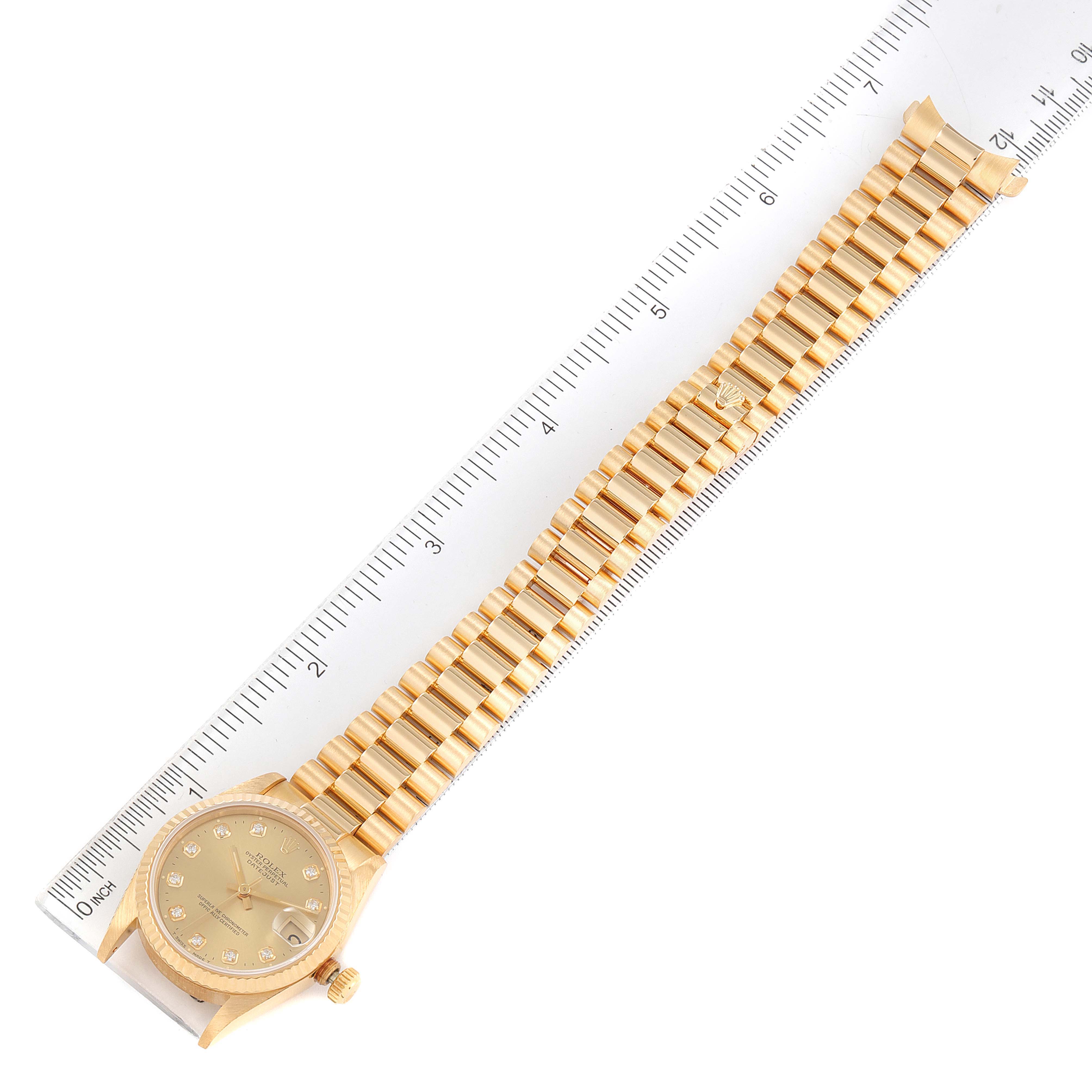 The Rolex President 68278 Women
s Yellow Gold Champagne Dial 68278 Women
s Yellow Gold Champagne Dial model watch is shown from an overhead perspective, including the face and full bracelet, alongside a ruler for scale.
