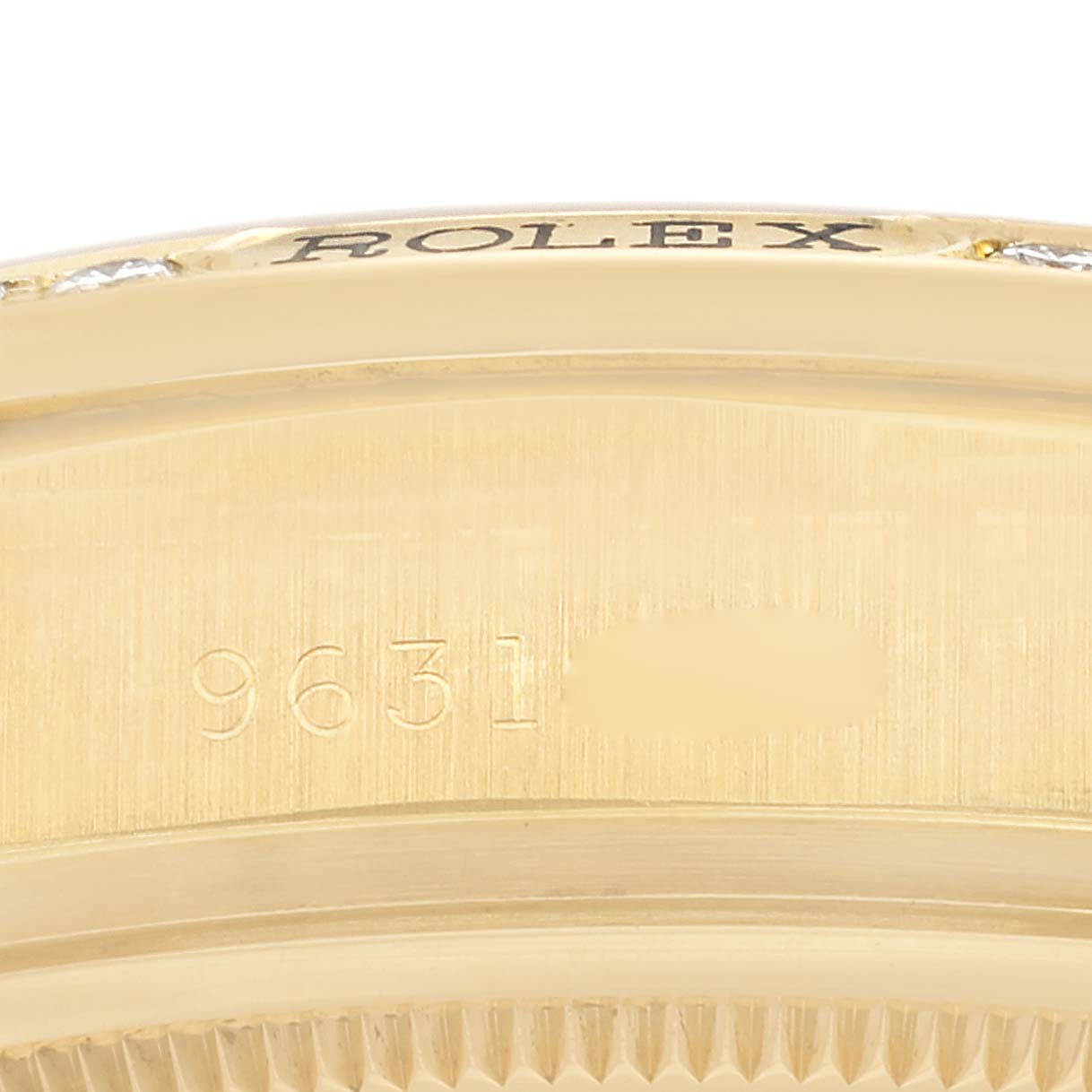 This close-up angle shows the side of a Rolex President 18138 Men
s Yellow Gold Champagne Dial 18138 Men
s Yellow Gold Champagne Dial model watch, featuring part of the bezel and the engraved serial number.