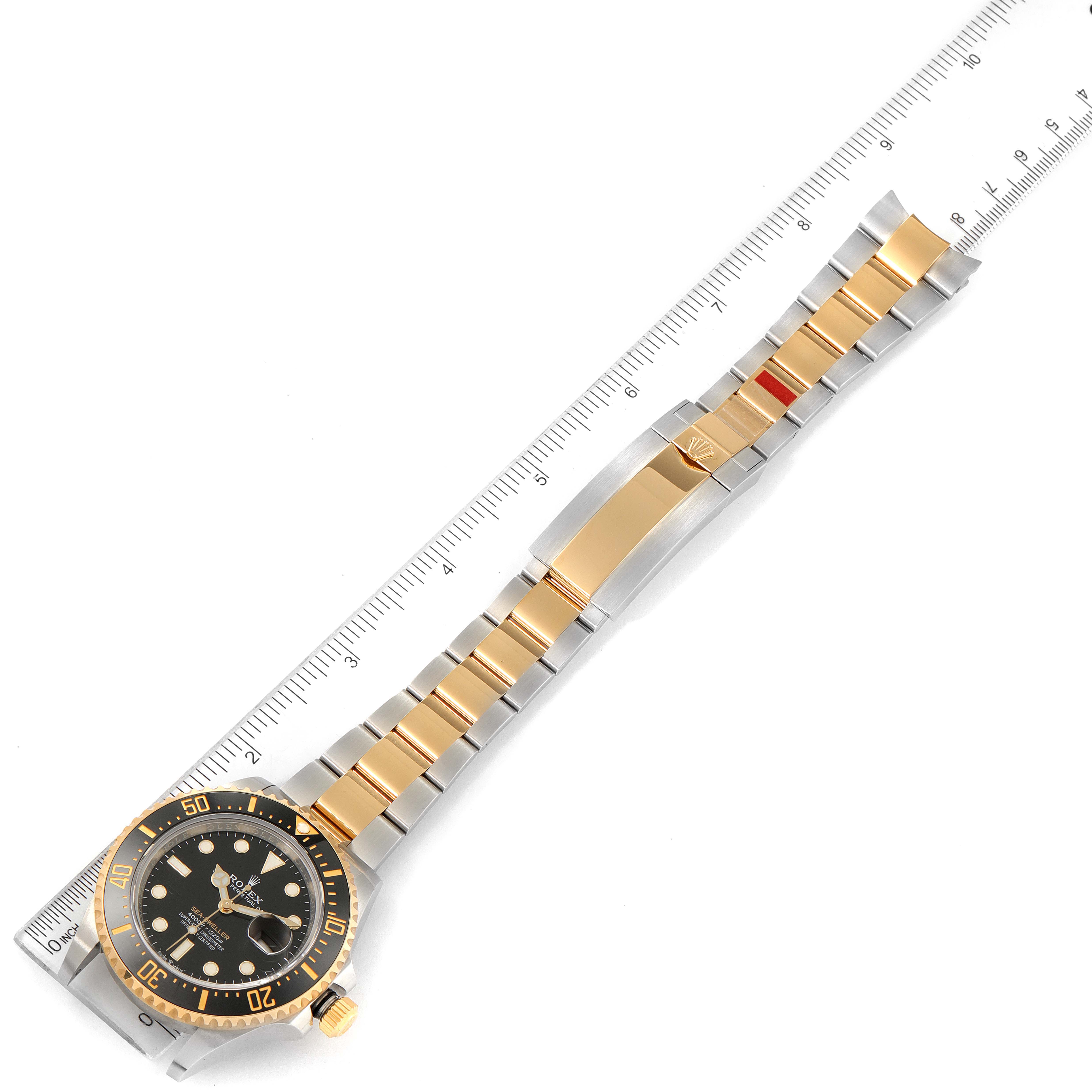 The Rolex Sea-Dweller 126603 Men
s Steel and Gold (two tone) Black Dial 126603 Men
s Steel and Gold (two tone) Black Dial watch is shown from an overhead angle with a ruler for scale, displaying its full bracelet and watch face.