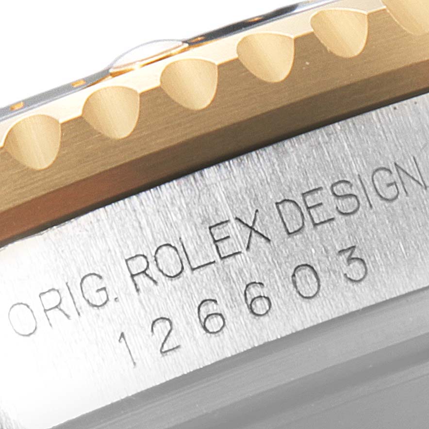 The close-up angle shows the Rolex Sea-Dweller 126603 Men
s Steel and Gold (two tone) Black Dial 126603 Men
s Steel and Gold (two tone) Black Dial
s bezel and part of the engraved model number on its case.