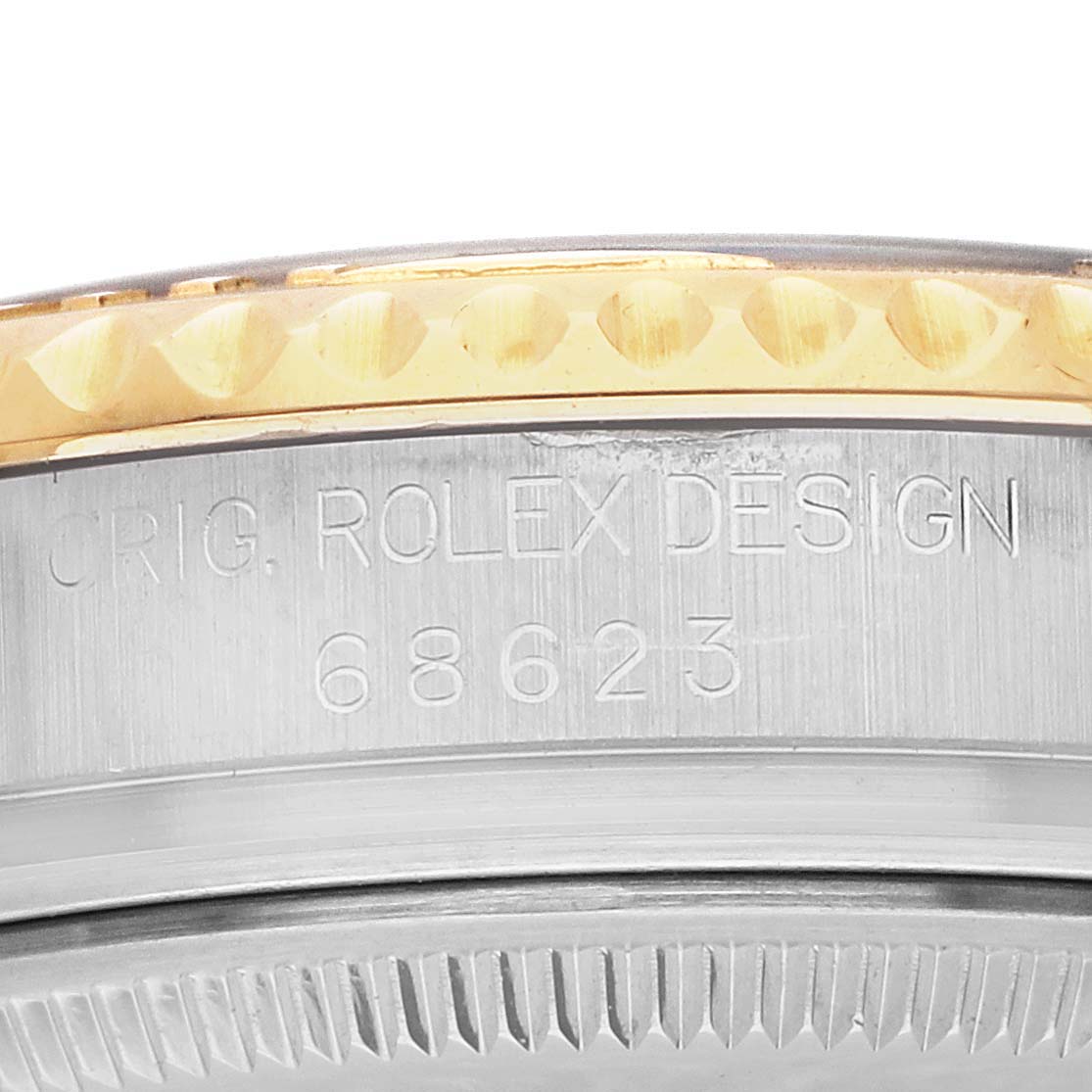 The image shows a side view of the Rolex Yacht-Master 68623 Men's Steel and Gold (two tone) Silver Dial 68623 Men's Steel and Gold (two tone) Silver Dial's bezel with engraved text and reference number.