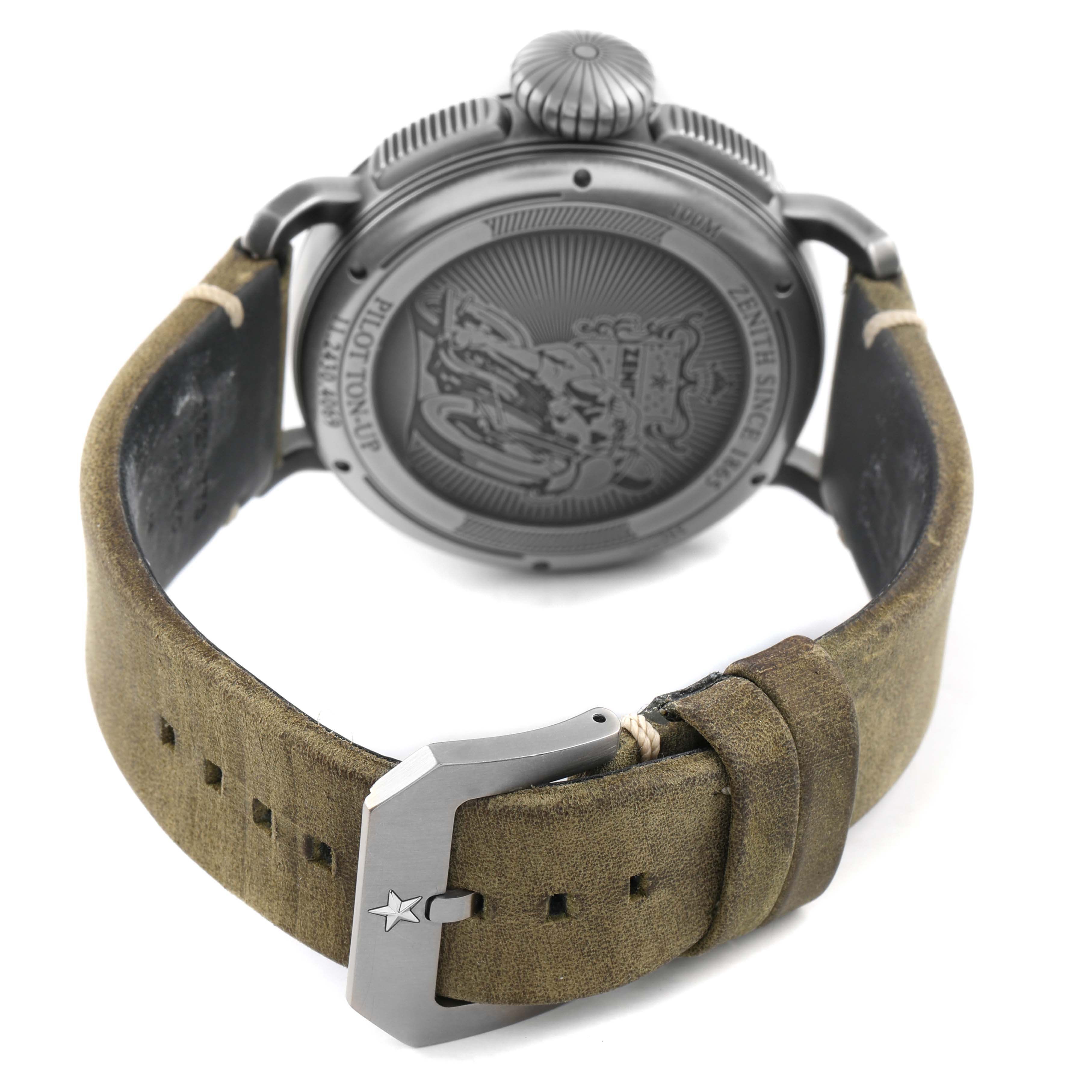 The Zenith Pilot 11.2430.4069 Men's Stainless Steel Grey Dial watch is shown from the back, highlighting the engraved case back, large crown, and leather strap with a buckle.