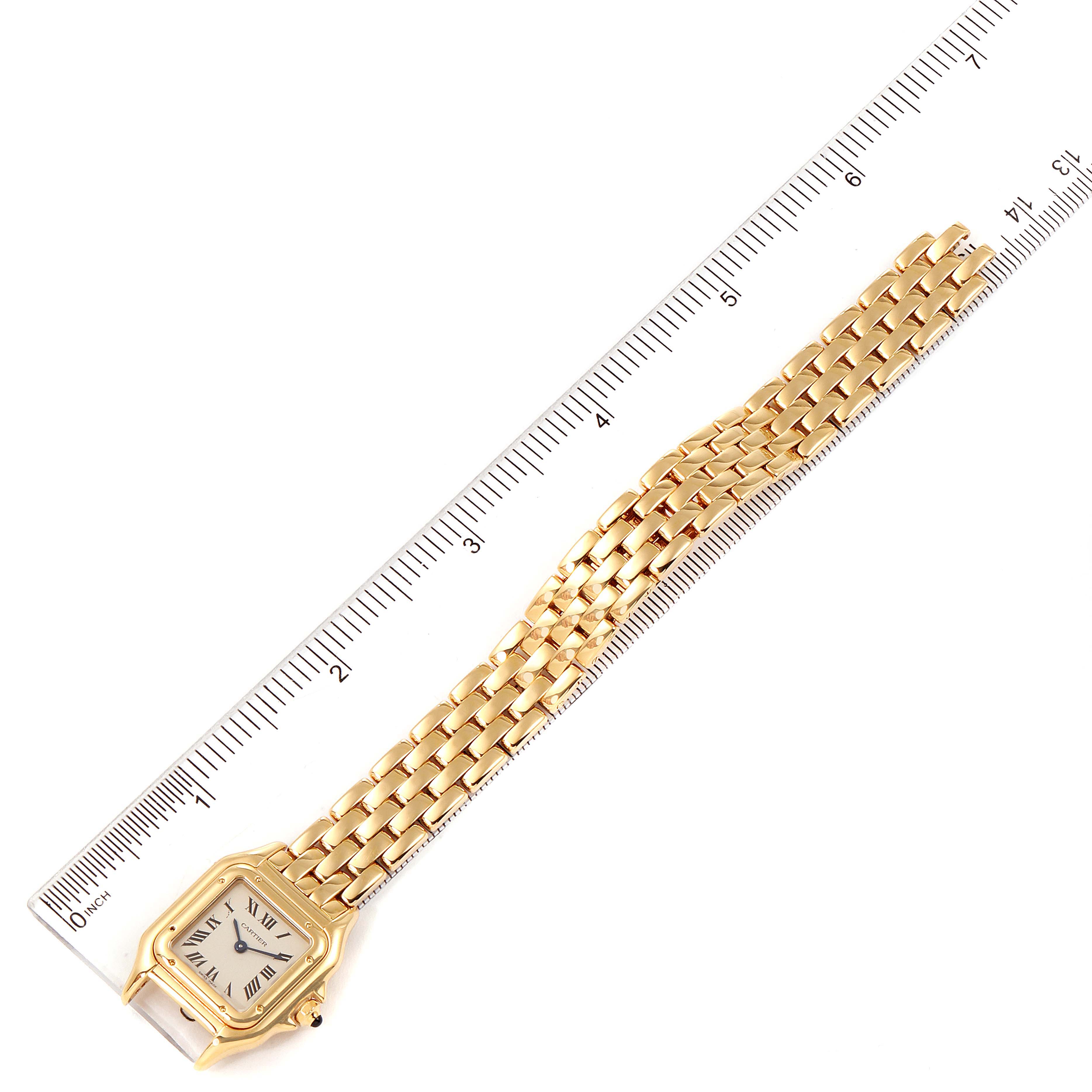 The image shows a Cartier Panthere W25022B9 Women's Yellow Gold Silver Dial W25022B9 Women's Yellow Gold Silver Dial watch placed next to a ruler, displaying the gold bracelet and square face.
